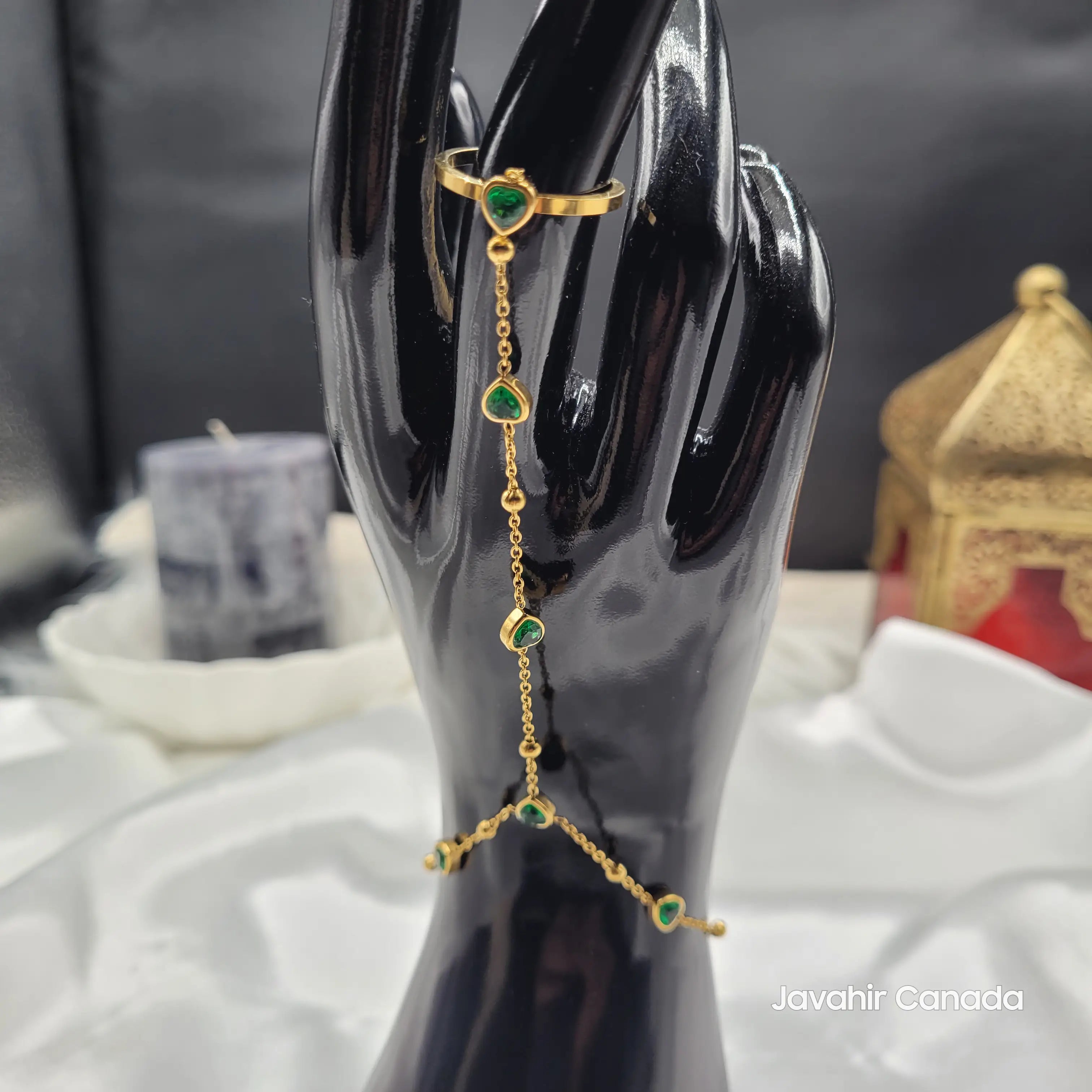 Angled shot of JV4023 gold haath phool with green heart-shaped charms