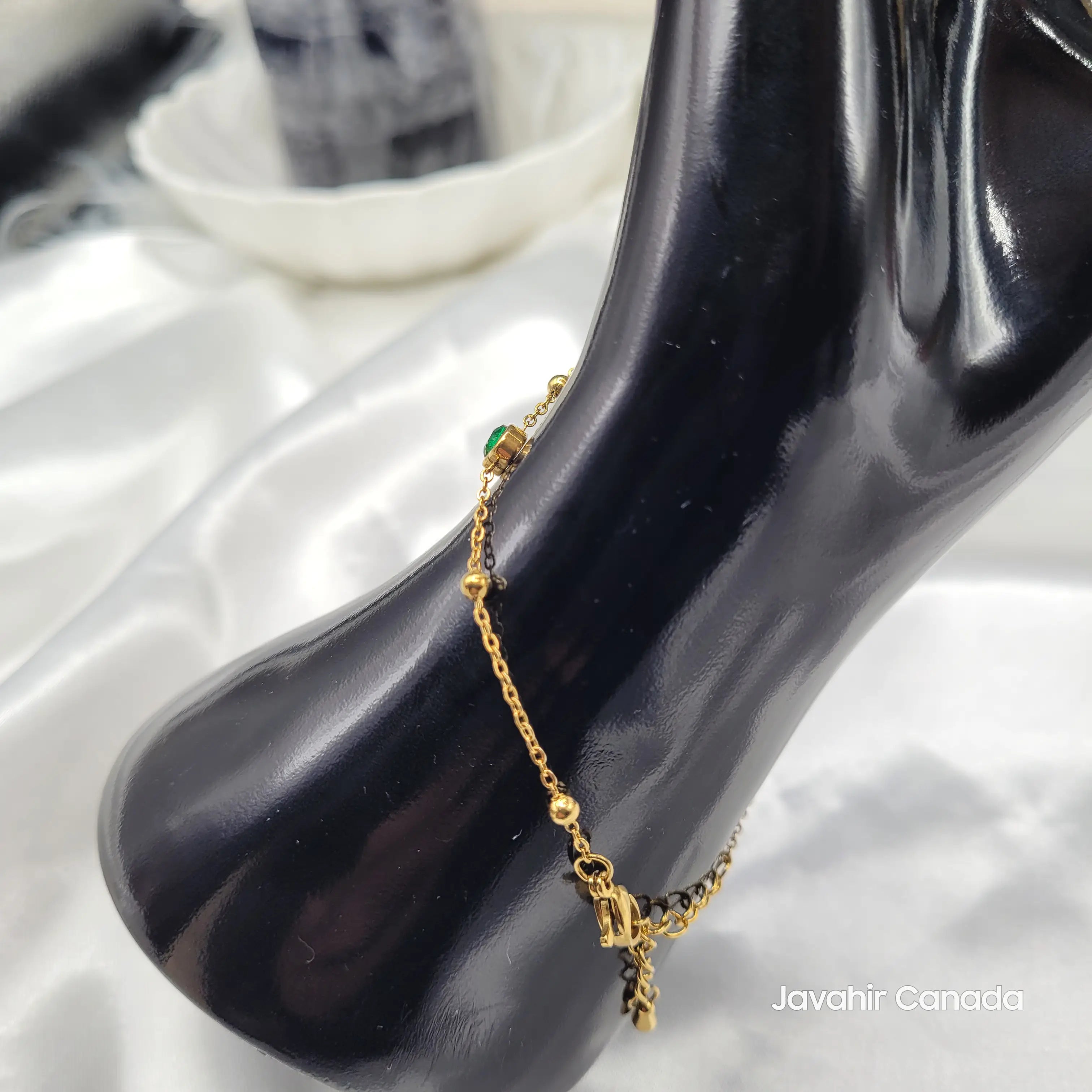 Close-up of gold wrist chain with green heart charm from JV4023 hand harness