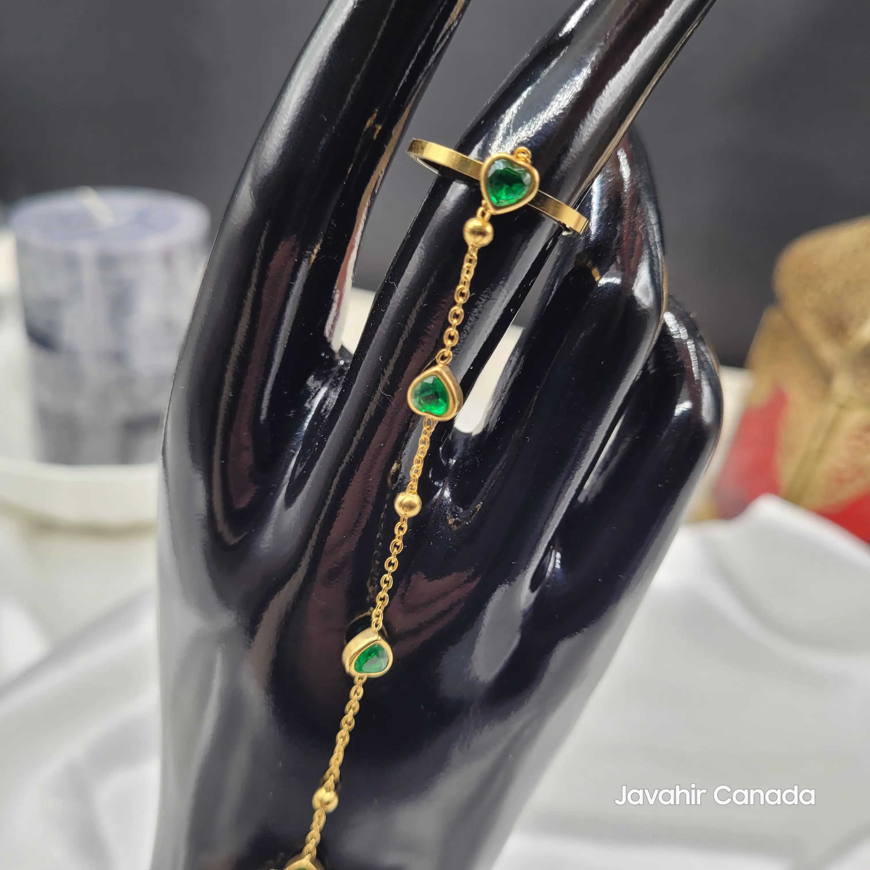 JV4023 gold haath phool bracelet with green heart stones on mannequin hand