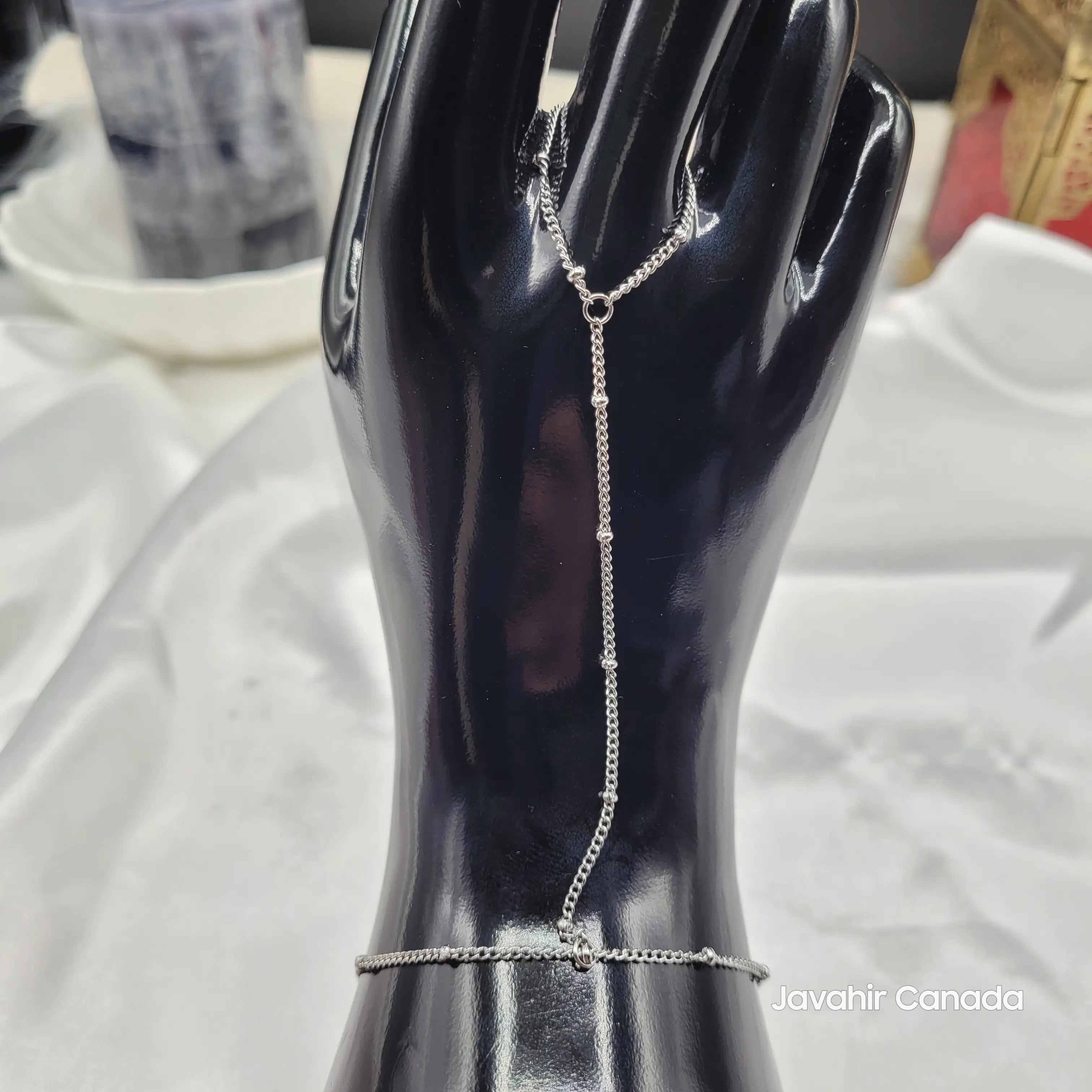 Full front view of JV4026 silver finger to wrist bracelet on black hand display