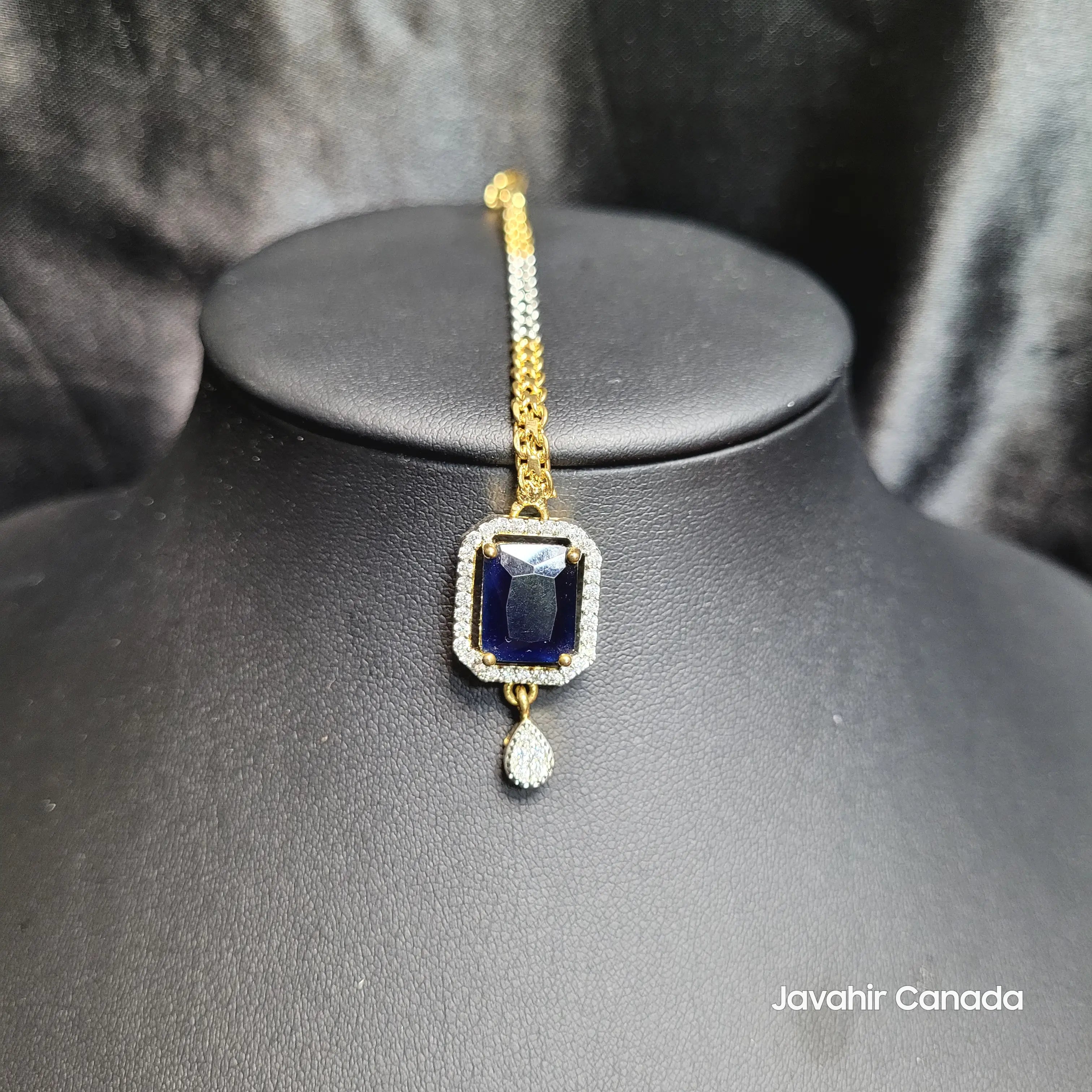 Traditional Maang Tikka with emerald-cut blue stone on display