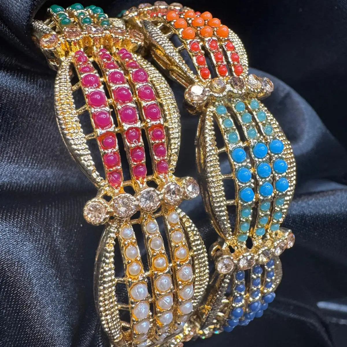 Kulfi bangles with vibrant beadwork and gold finish on black satin