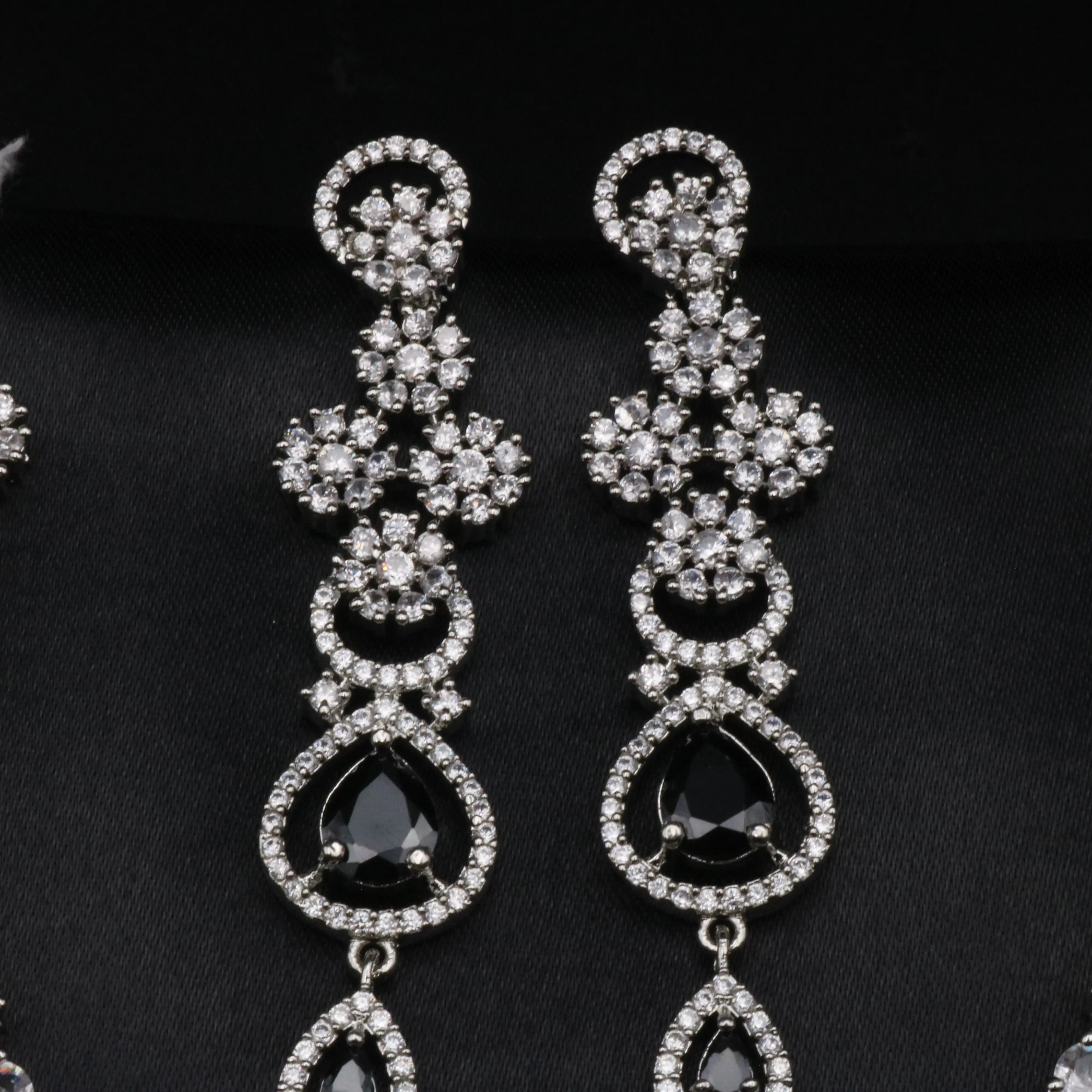 Detailed top view of black earrings with floral CZ clusters and elegant drop design.