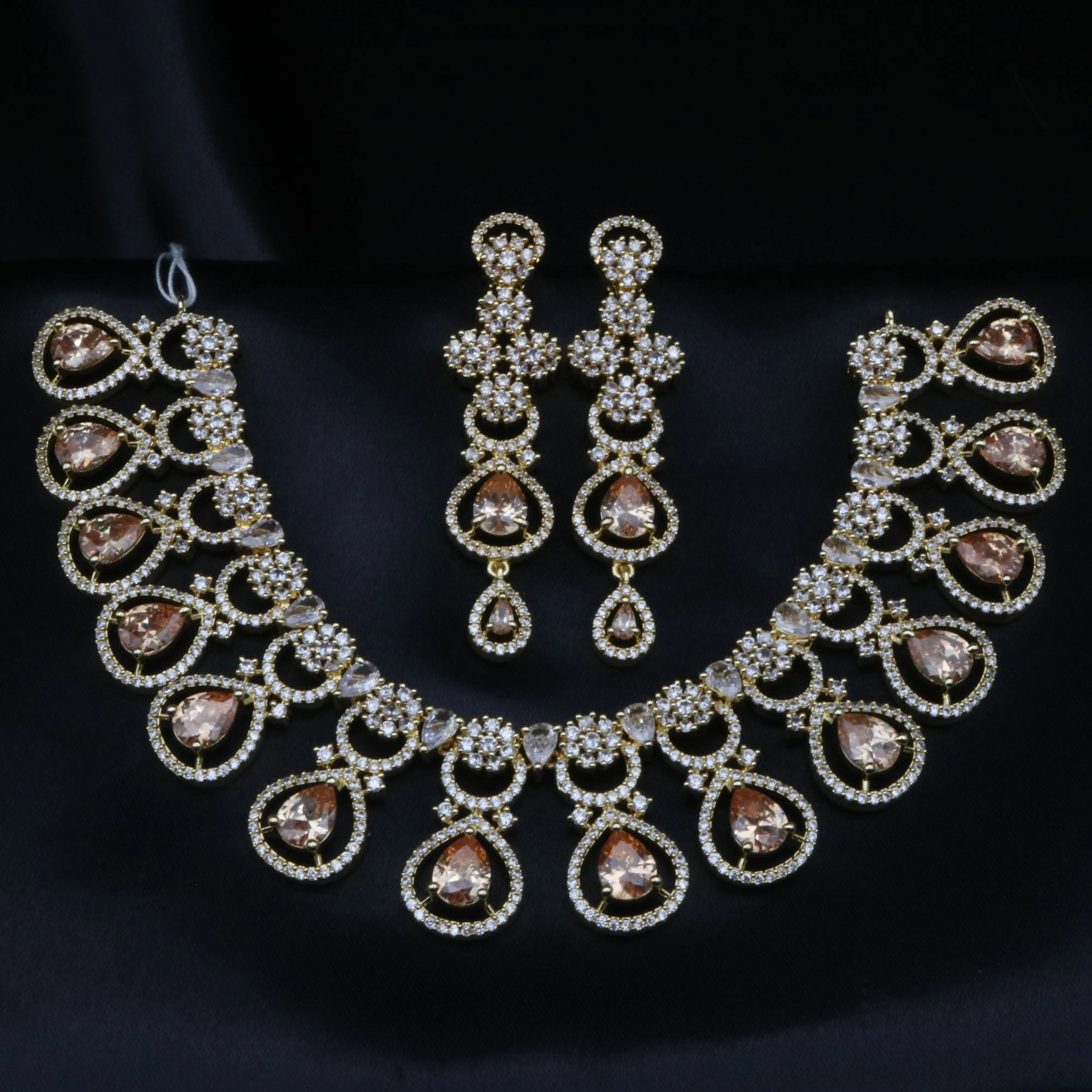 Luxurious bridal necklace set featuring champagne pear-cut CZ stones and matching chandelier earrings on gold plating