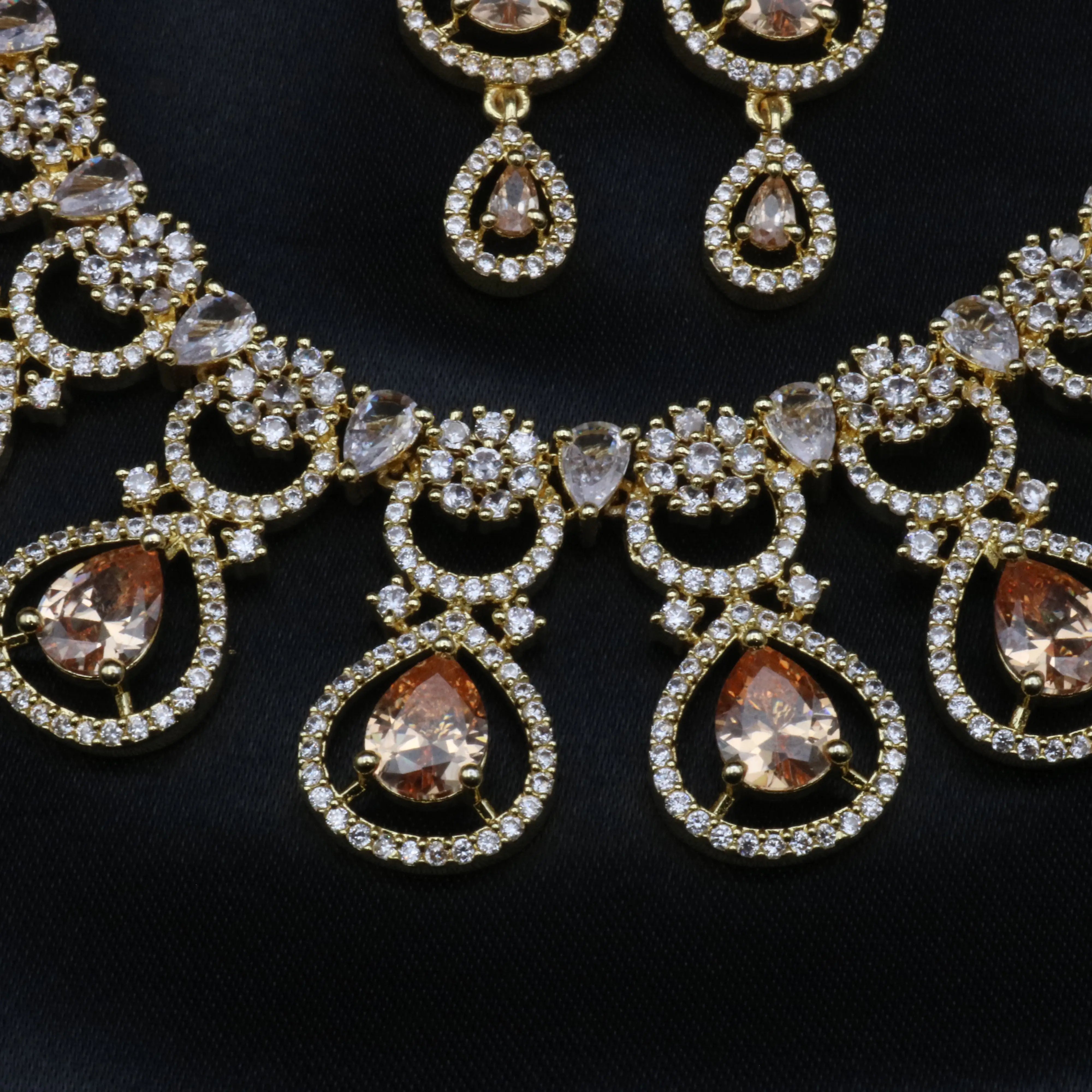 Close-up of pear-shaped champagne CZ centerpiece with American diamond halo on necklace