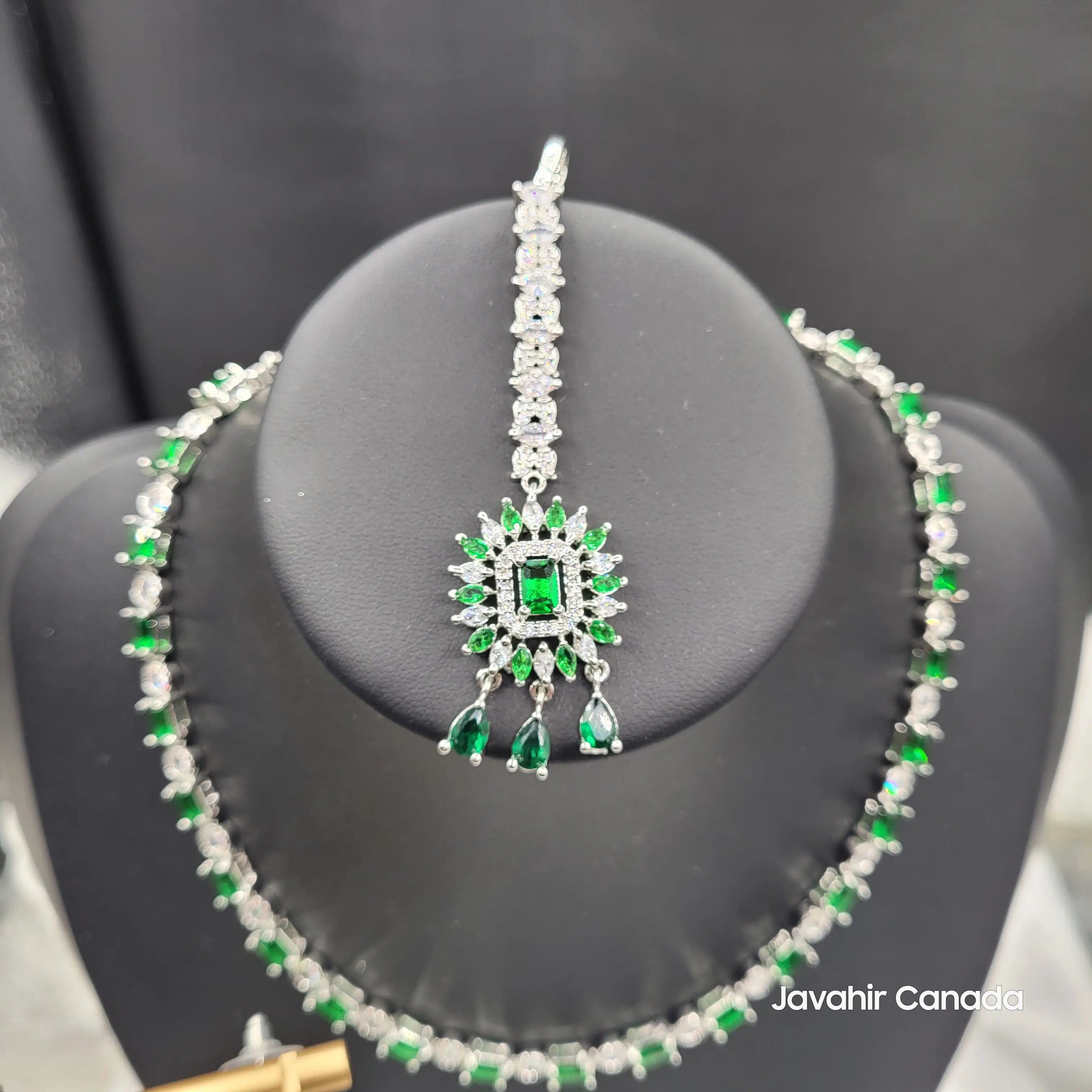 Highlight on Luna’s maang tikka featuring a central green stone surrounded by marquise-cut American diamonds.
