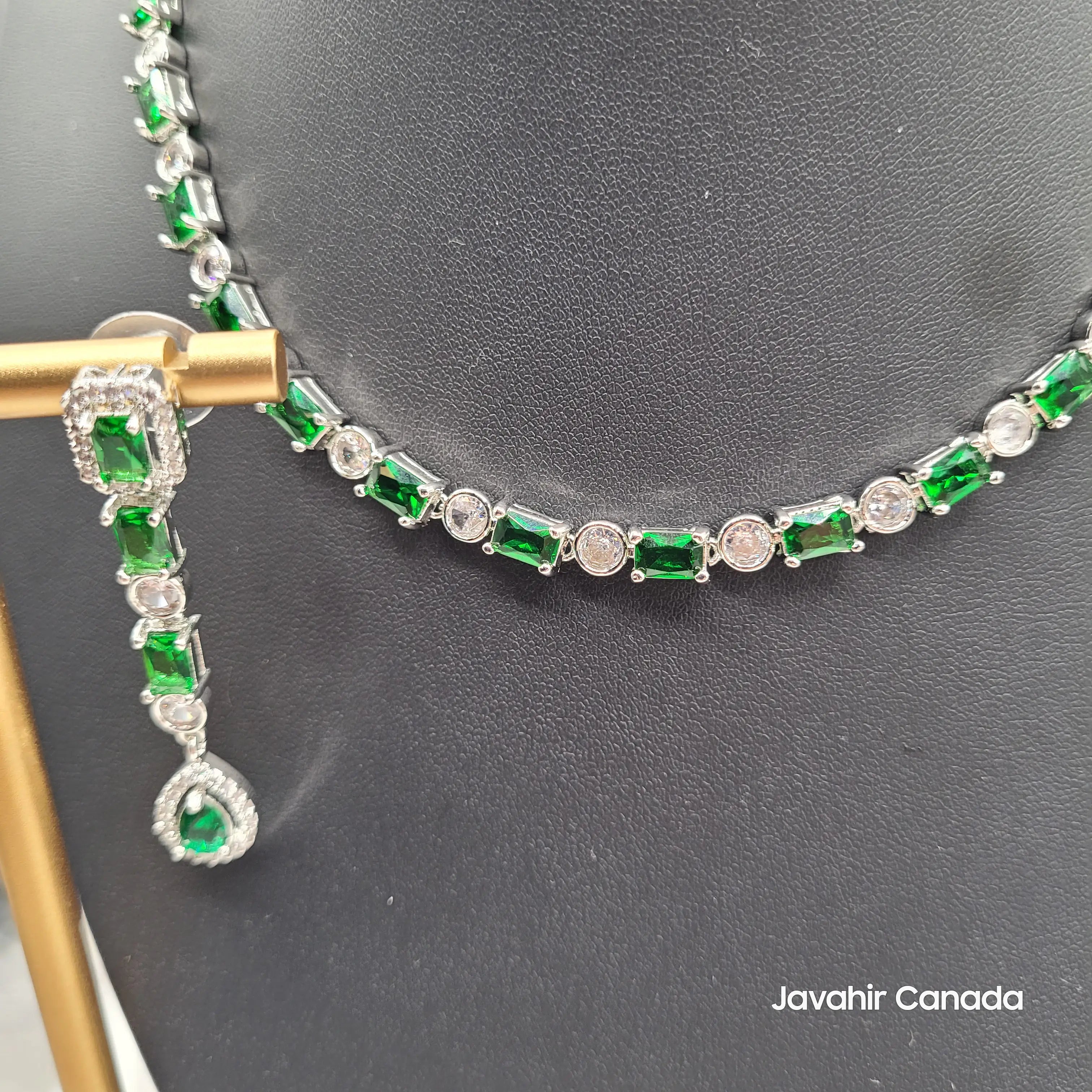 Detail view of Luna necklace showing alternating green and white zircon stones in silver-tone setting.