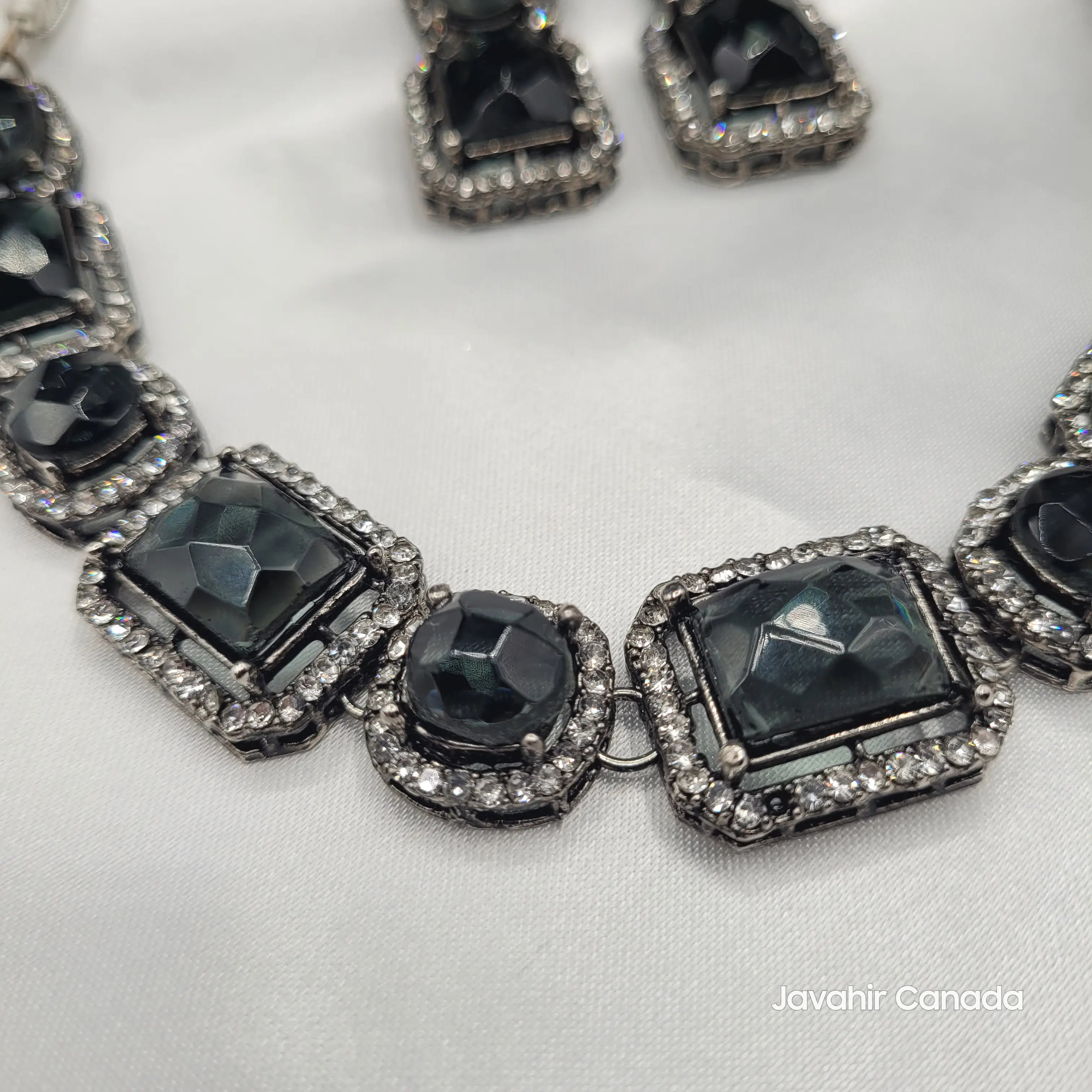 Close-up of Maharaj black necklace showing faceted rectangular and round stones with halo