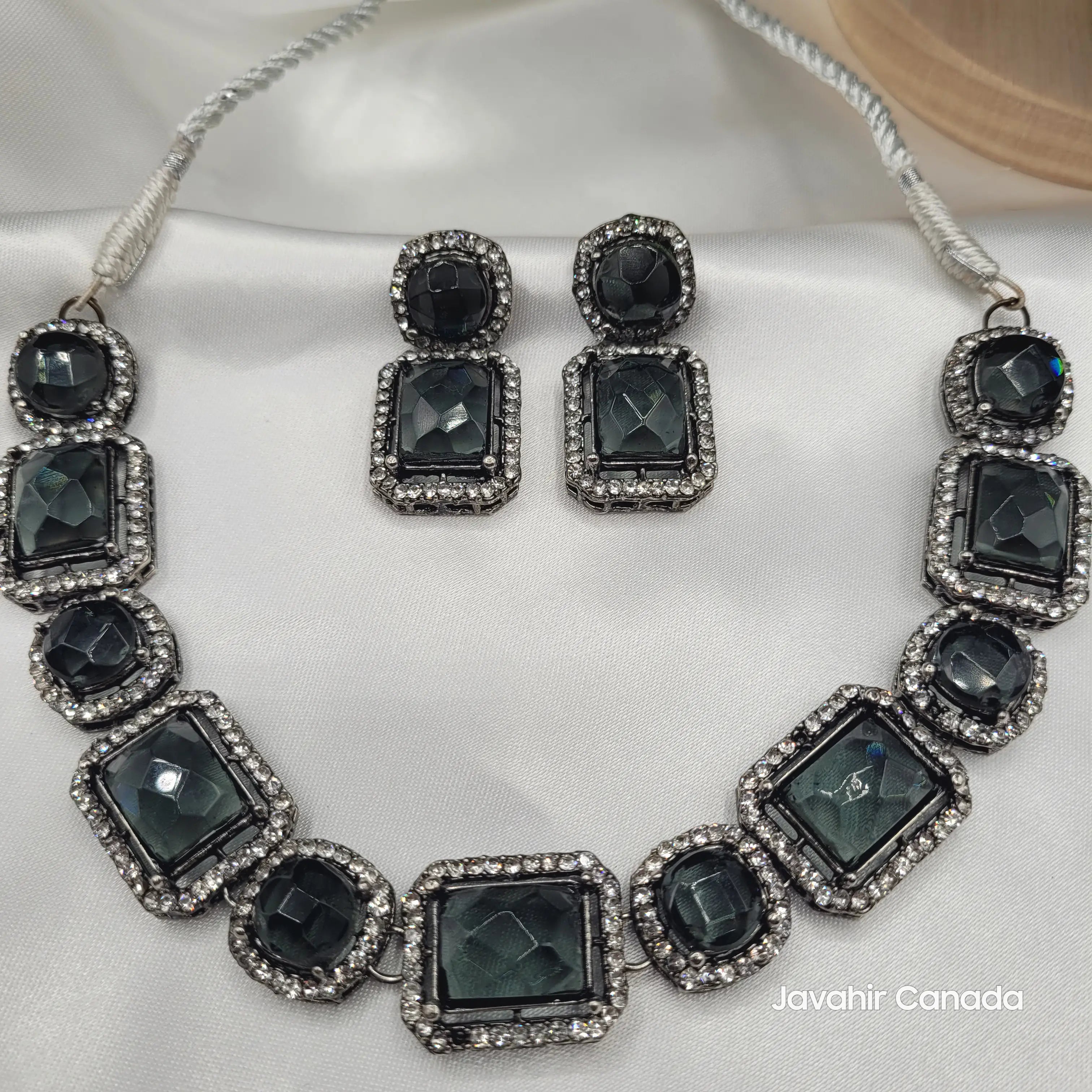 Full Maharaj black stone necklace set displayed on white satin background