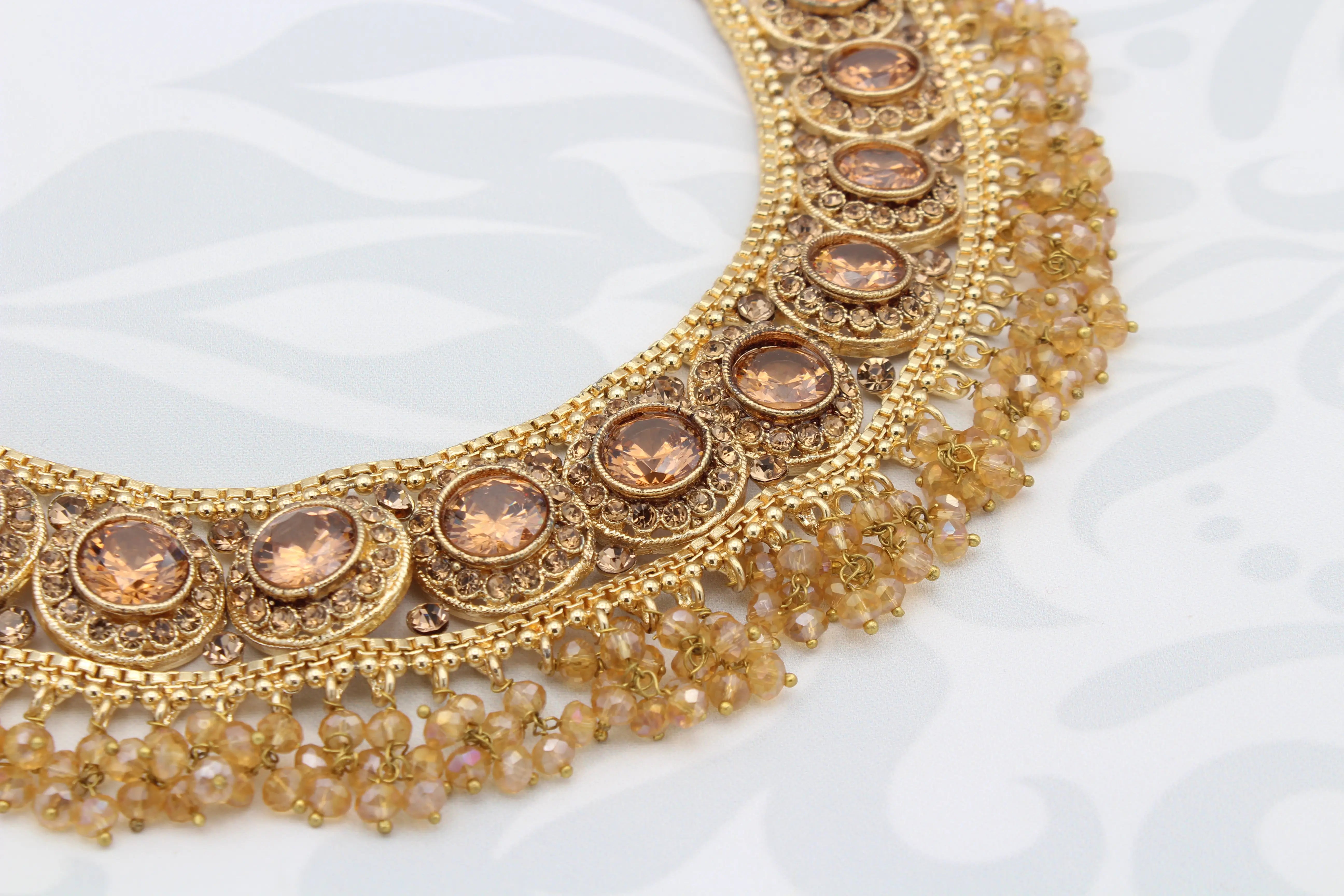 Close-up of gold-plated Manjoos Necklace showing intricate detailing and gemstone settings