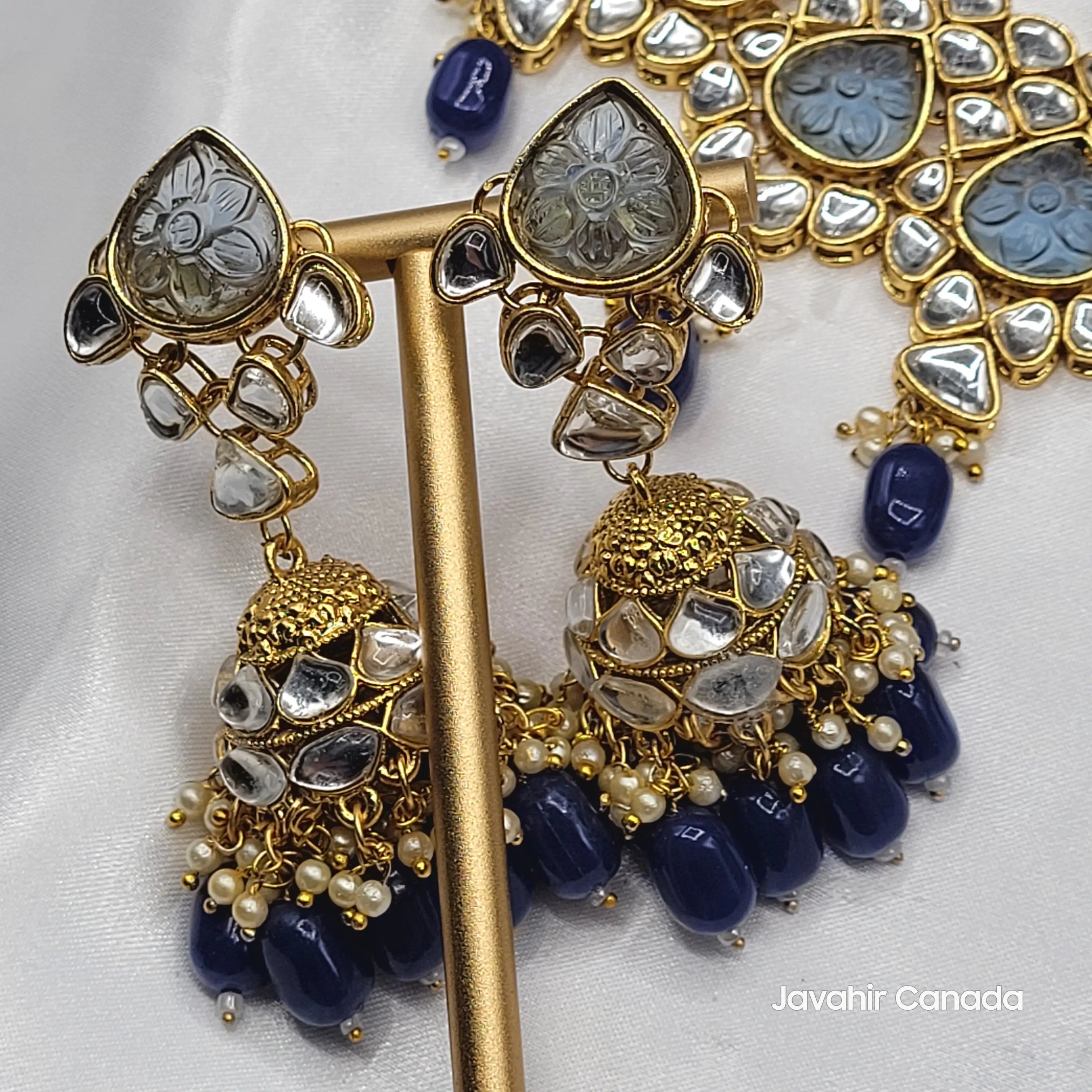Side view of Marina earrings and necklace highlighting intricate floral carving on stones and kundan settings.