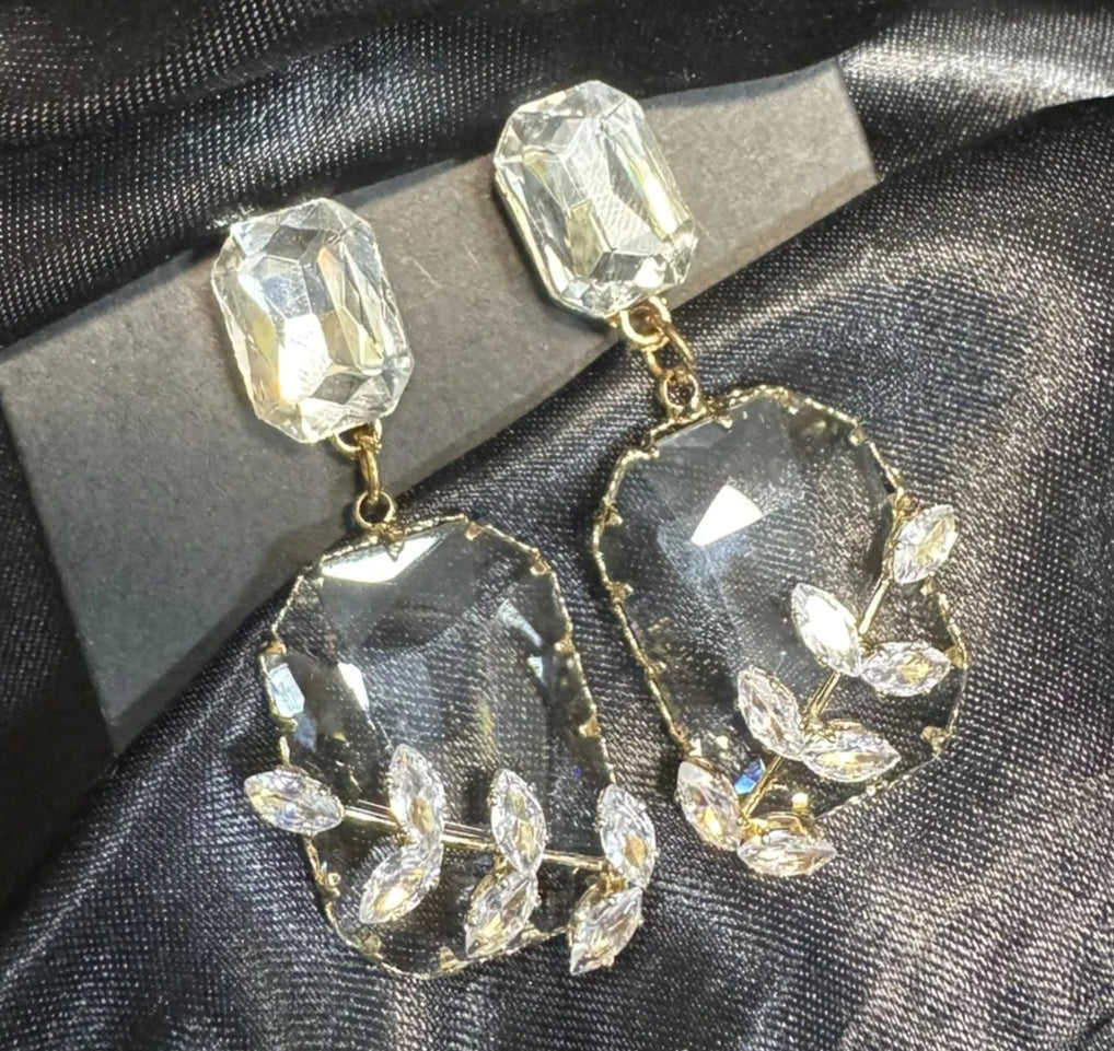 Pair of crystal earrings on a black satin background
