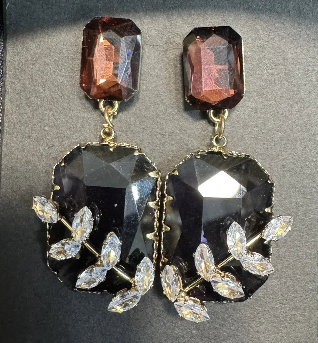 Pair of earrings on a black card with a dark background