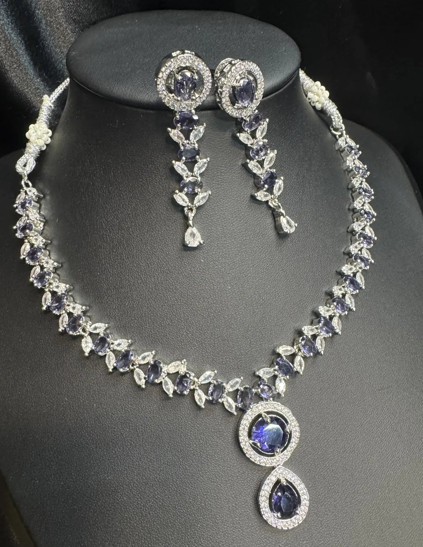 Jewelry set with necklace and earrings on a mannequin bust.