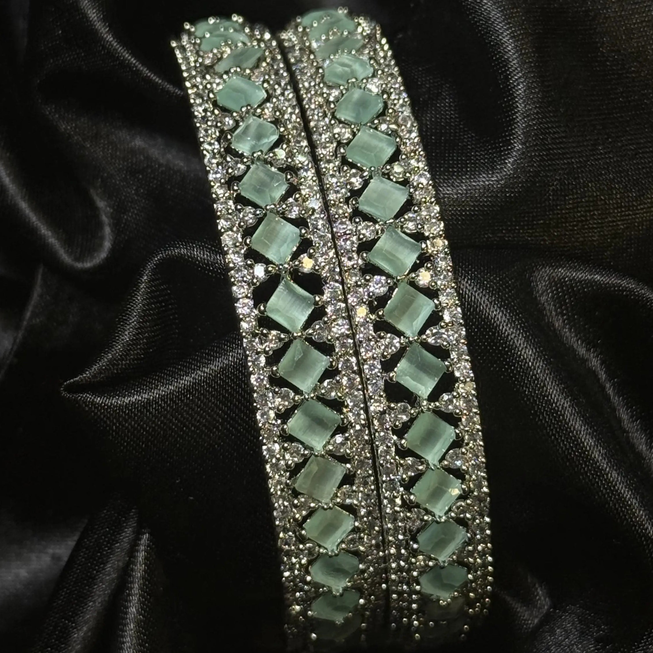 Silver-toned bangles with teal square stones and zircon accents