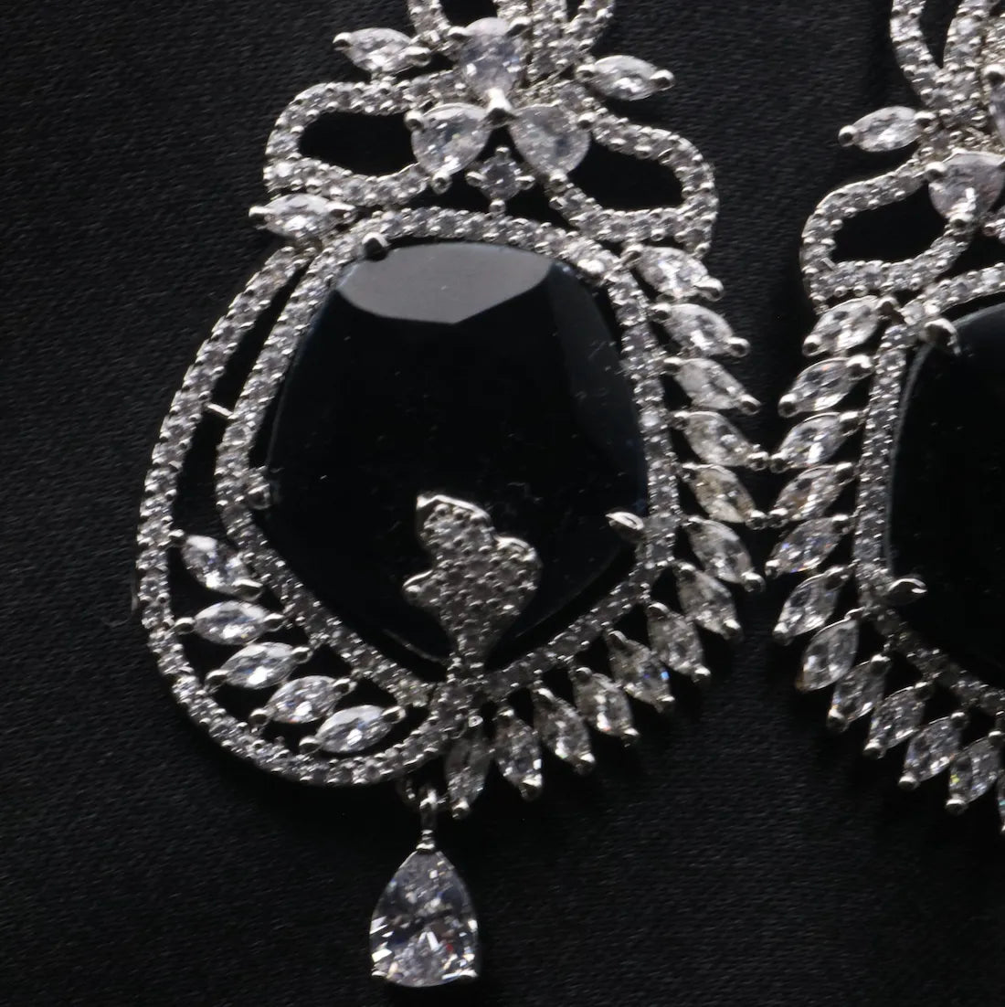 Silver American diamonds earrings with blue gemstones on a dark background