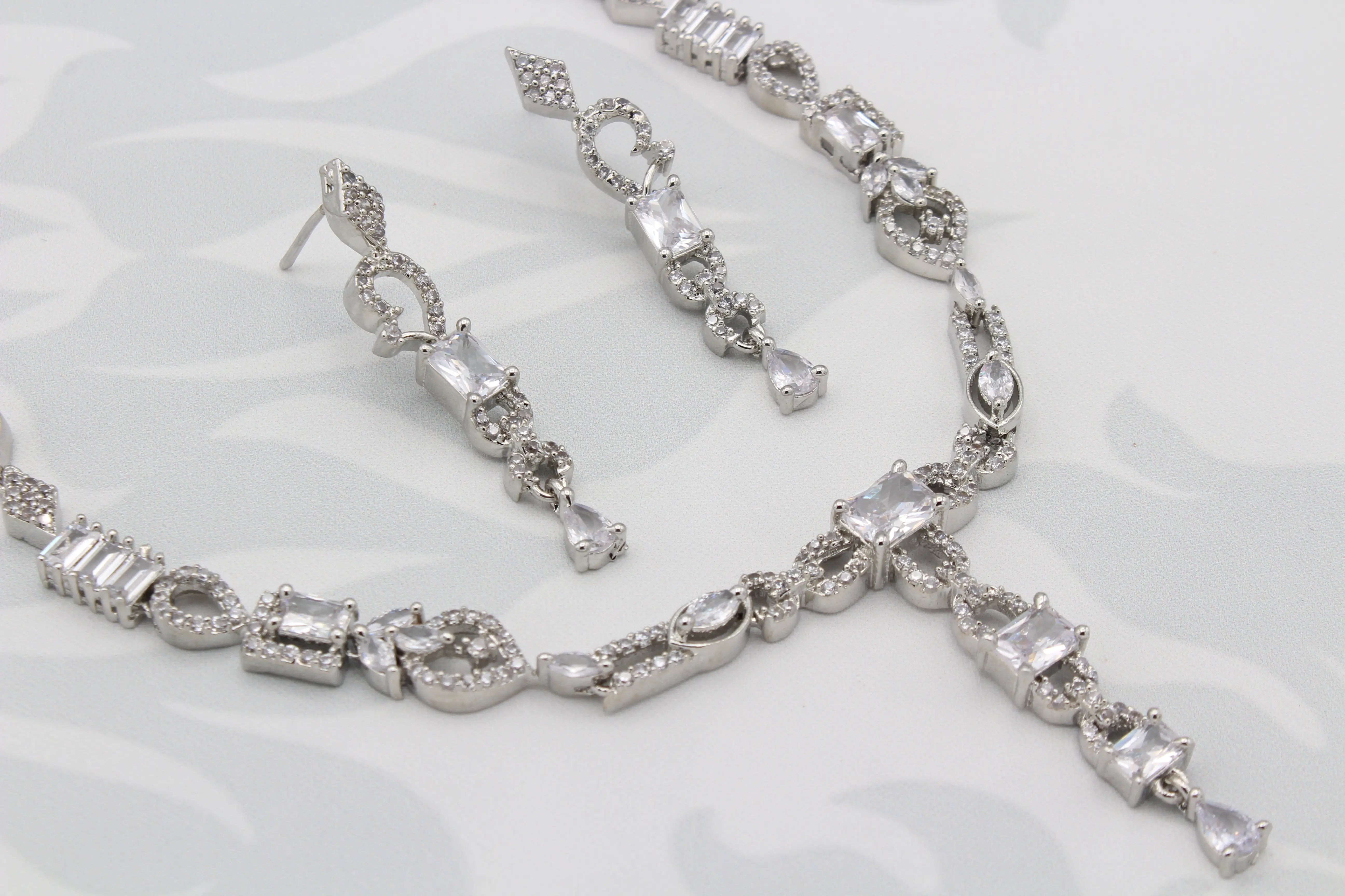 Close-up of Twinning Vine earrings and necklace showcasing geometric CZ stones