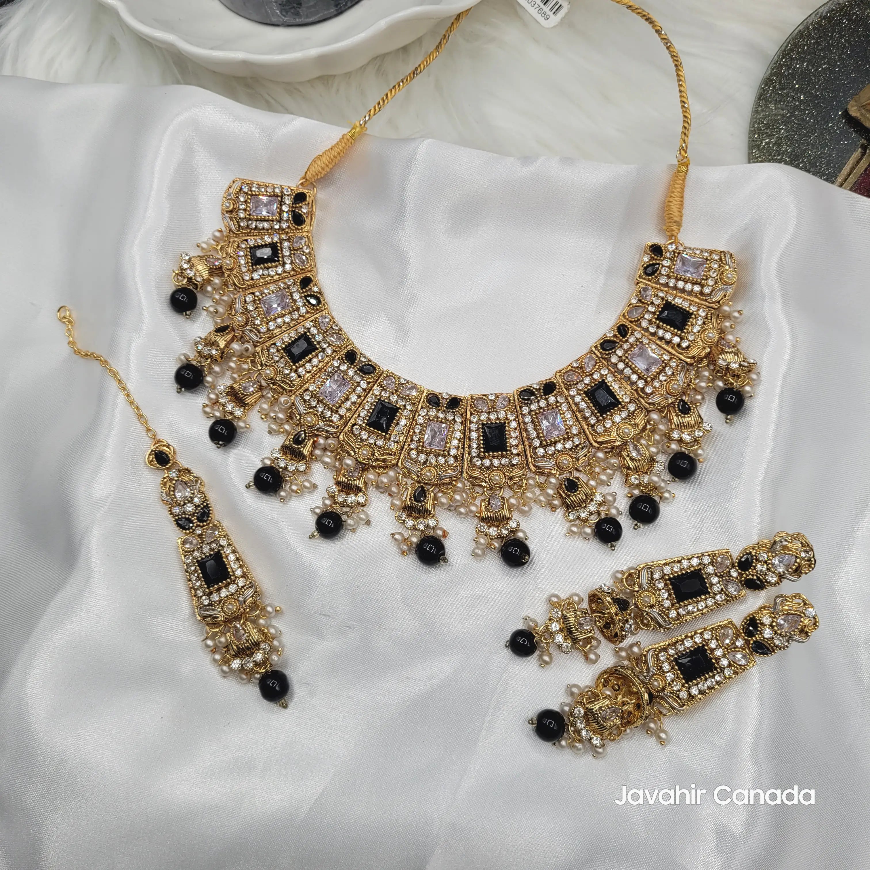Ornate gold and black jewelry set on a white fabric background with 'Javahir Canada' branding.