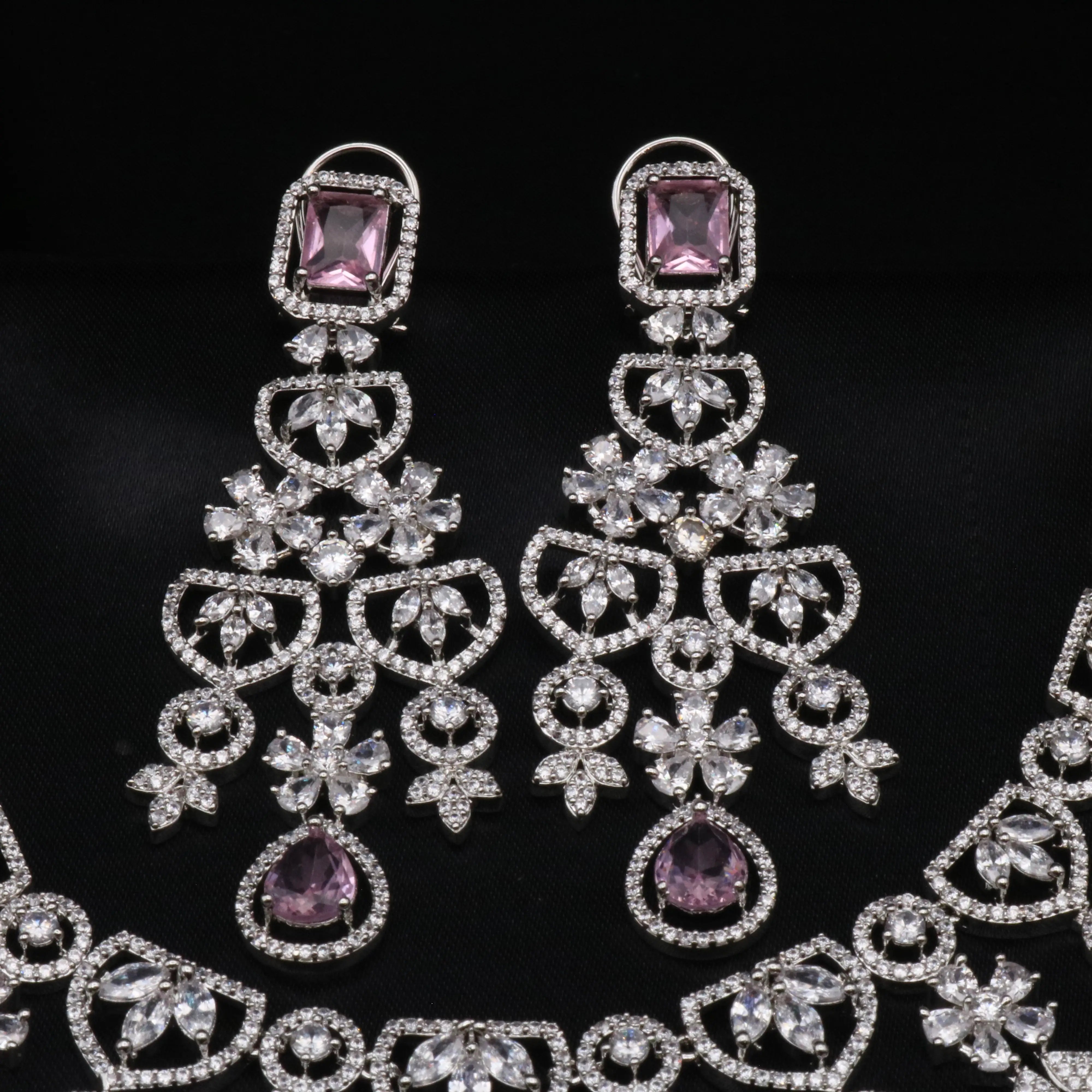 Detailed view of chandelier earrings with lavender CZ tops and intricate diamond floral patterns.