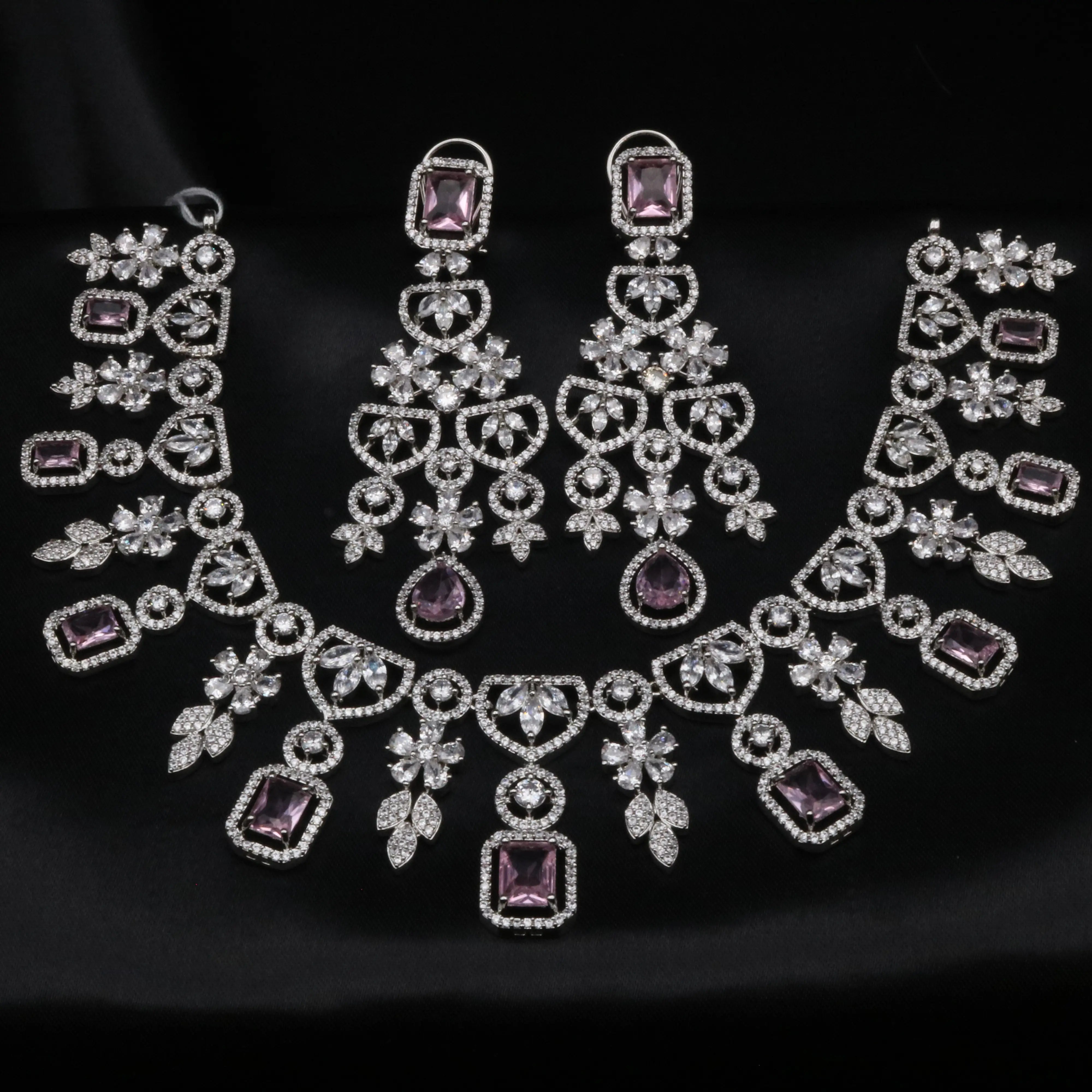 Barbie necklace and earrings set with lavender CZ stones and American diamonds on a black background.