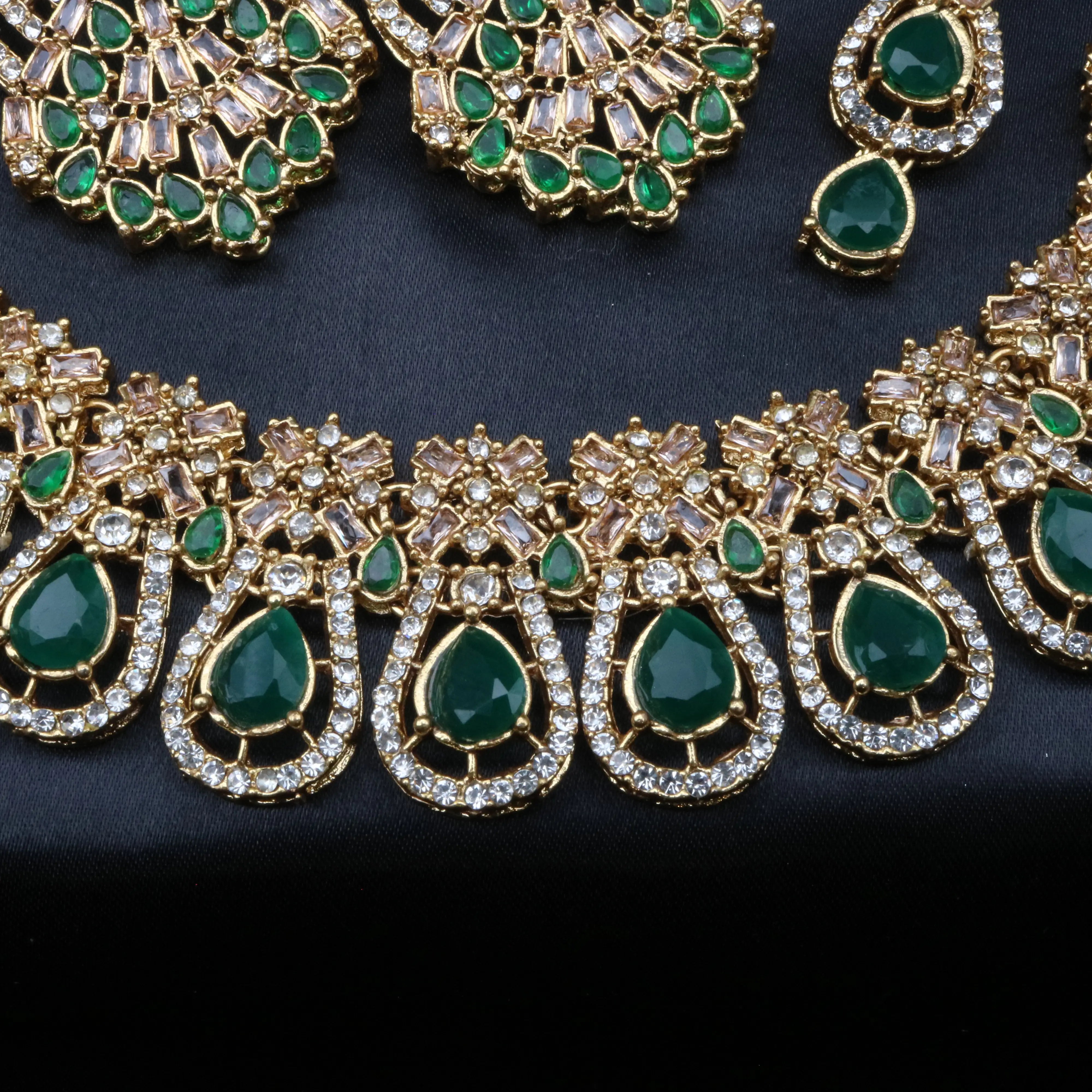 Close-up of Calypso necklace in green CZ stones and gold plating with intricate American diamond detailing