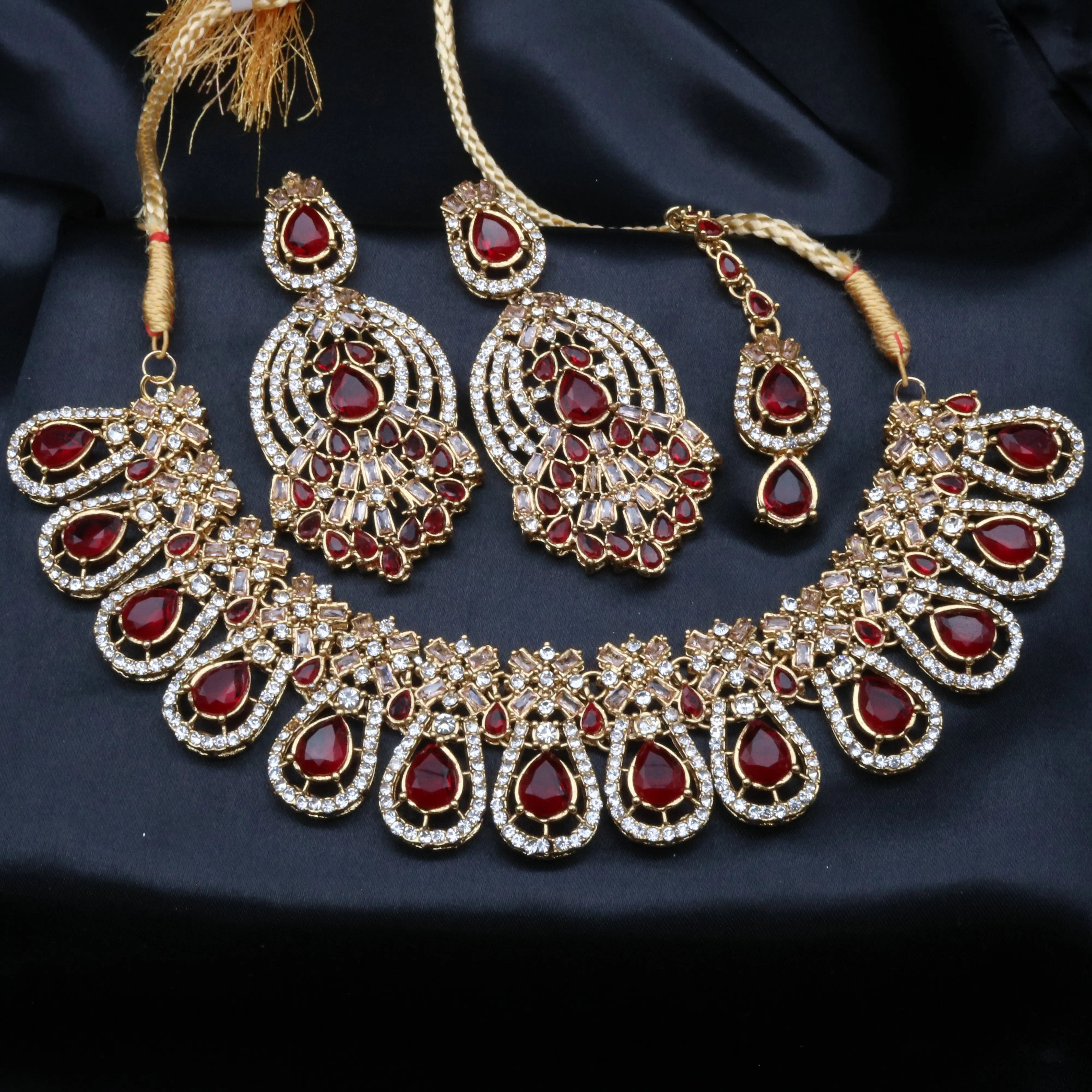 Calypso party wear necklace set in red with American diamonds, gold finish, earrings and teeka