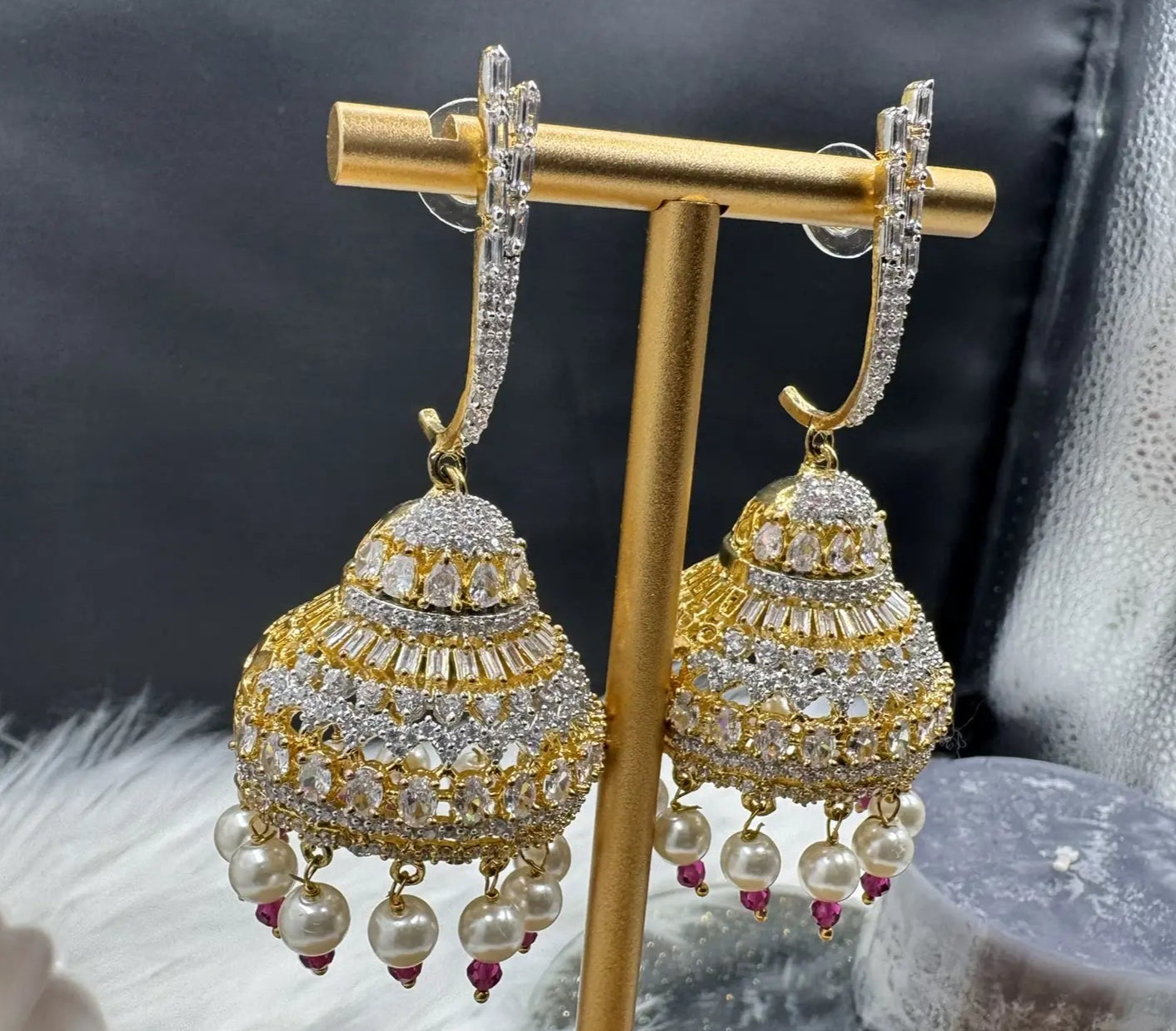 left frontal view of Pakistani design jhumkay with jarao craftsmanship. Clear gemstones with pearl accents providing an exquisite touch.