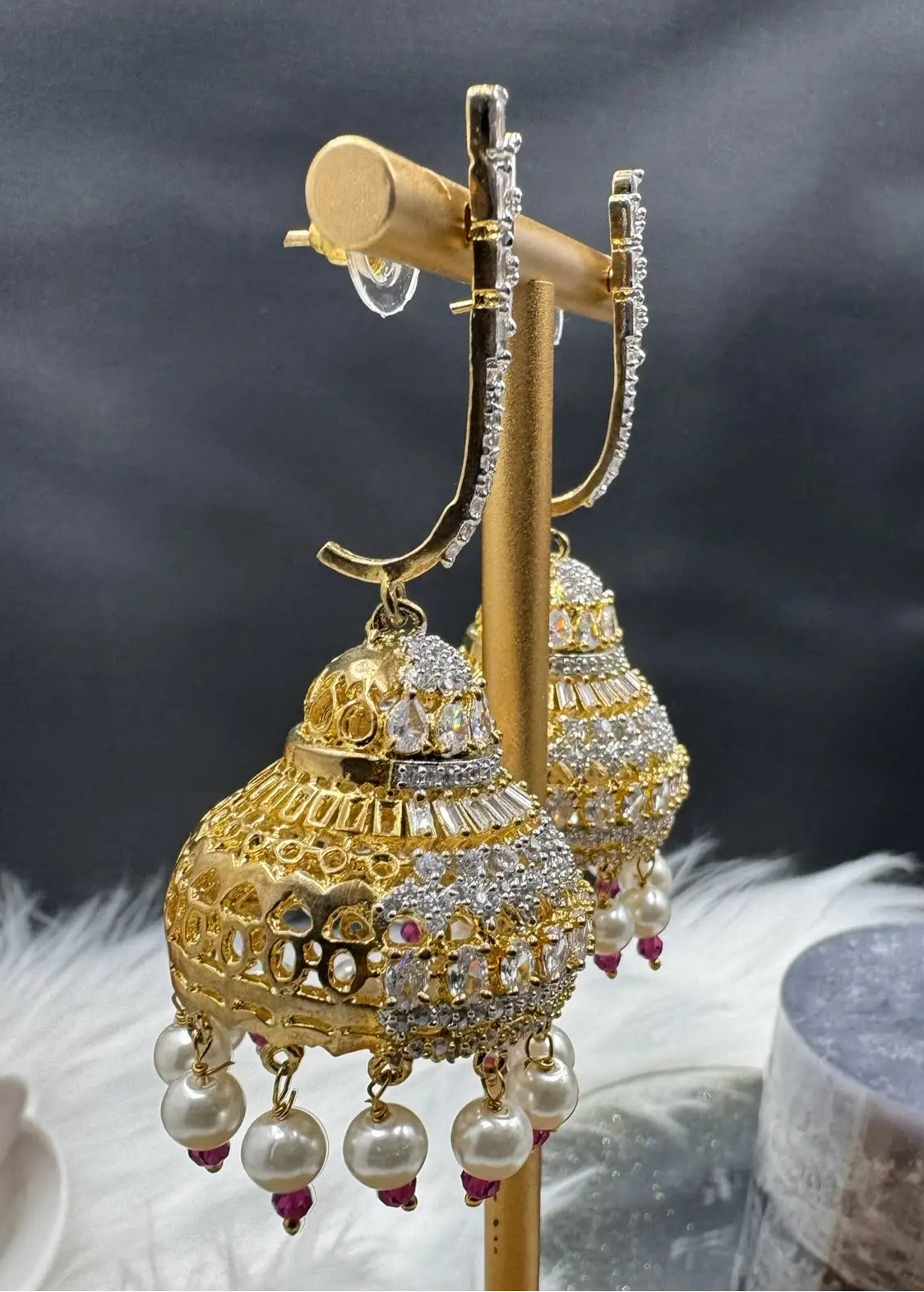 side view of Pakistani design jhumkay with jarao craftsmanship. Clear gemstones with pearl accents providing an exquisite touch.