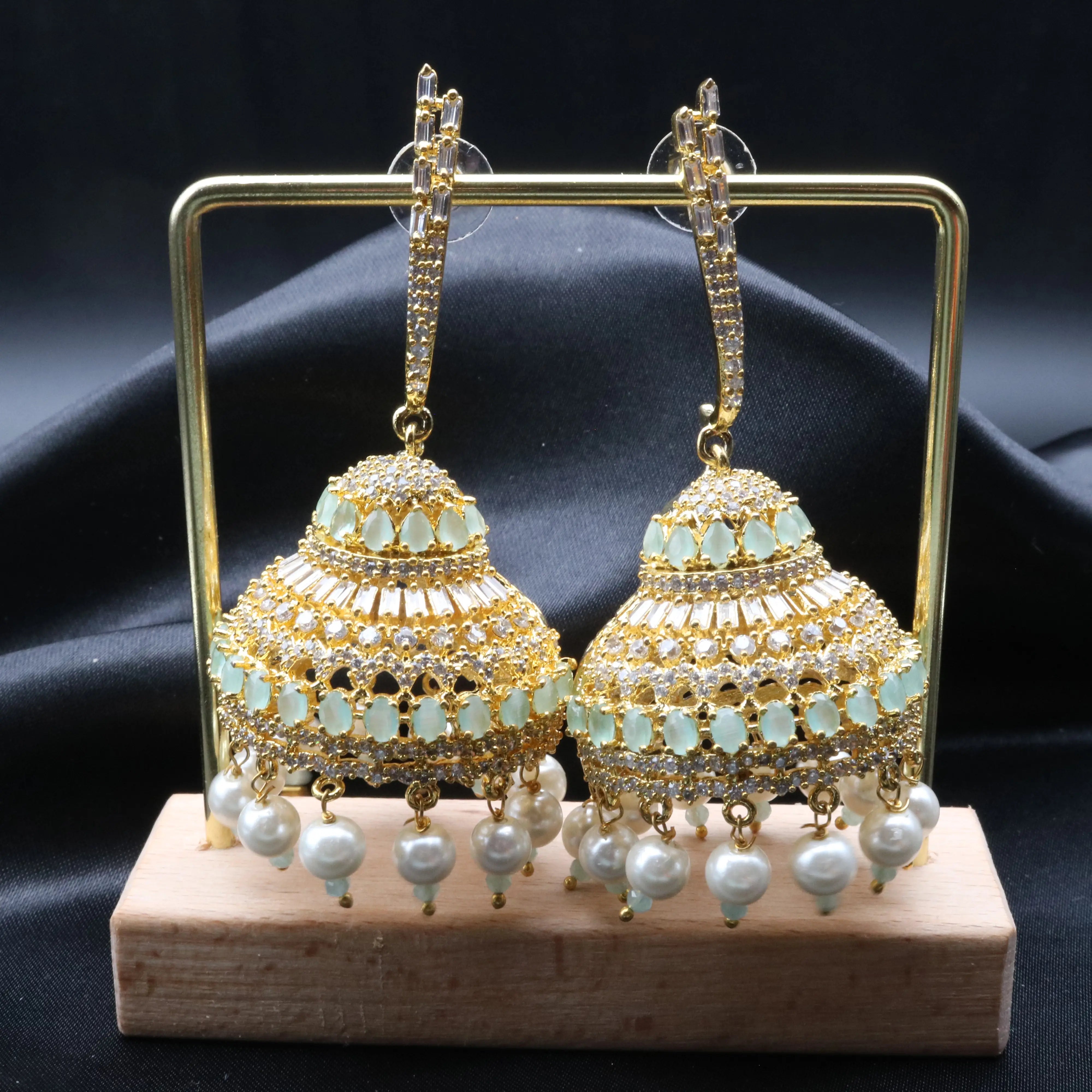 Pakistani design jhumkay with jarao craftsmanship. Teal and clear gemstones with pearl accents providing an exquisite touch.