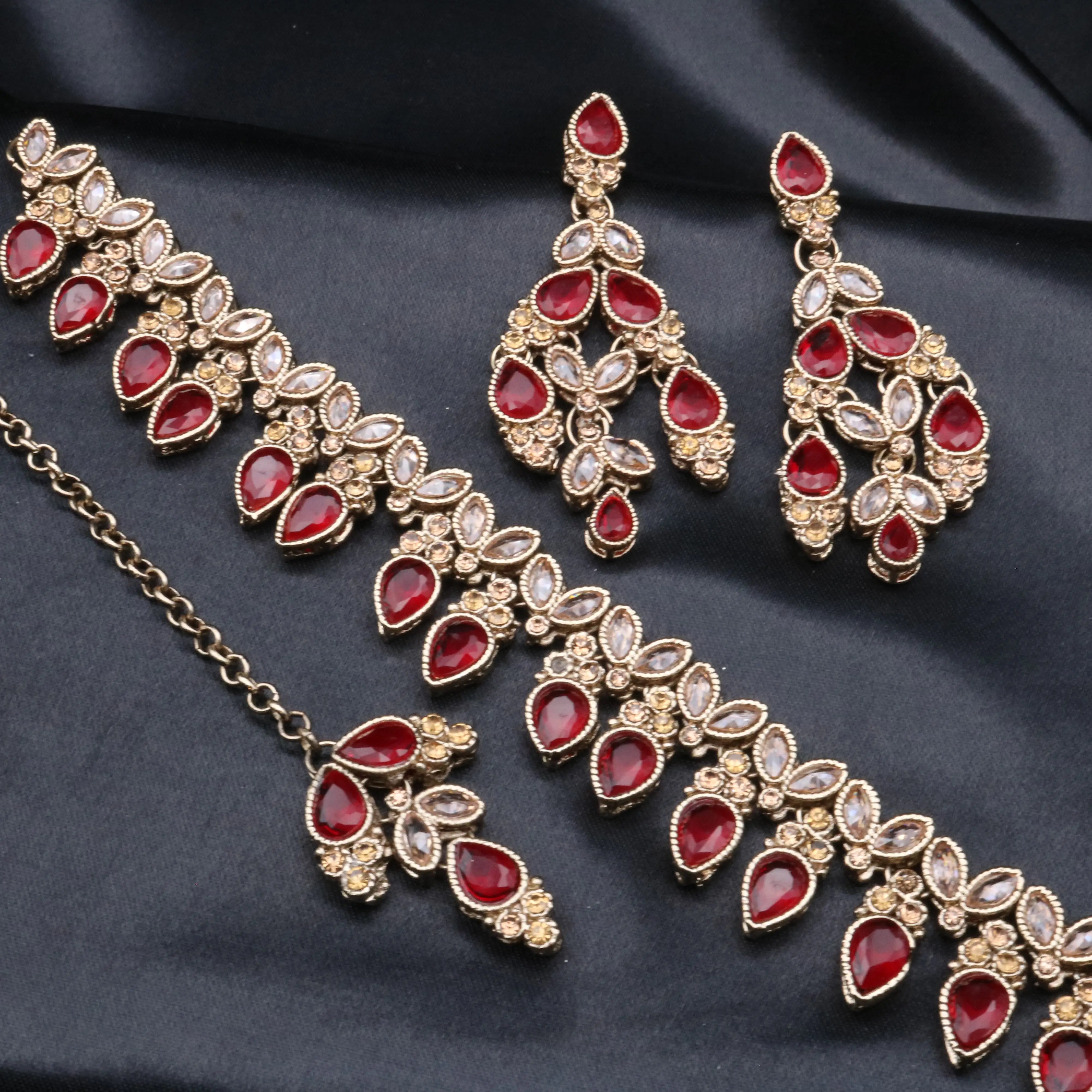 Top view of Cleo ruby variant showing matching earrings, teeka and necklace with detailed floral accents.