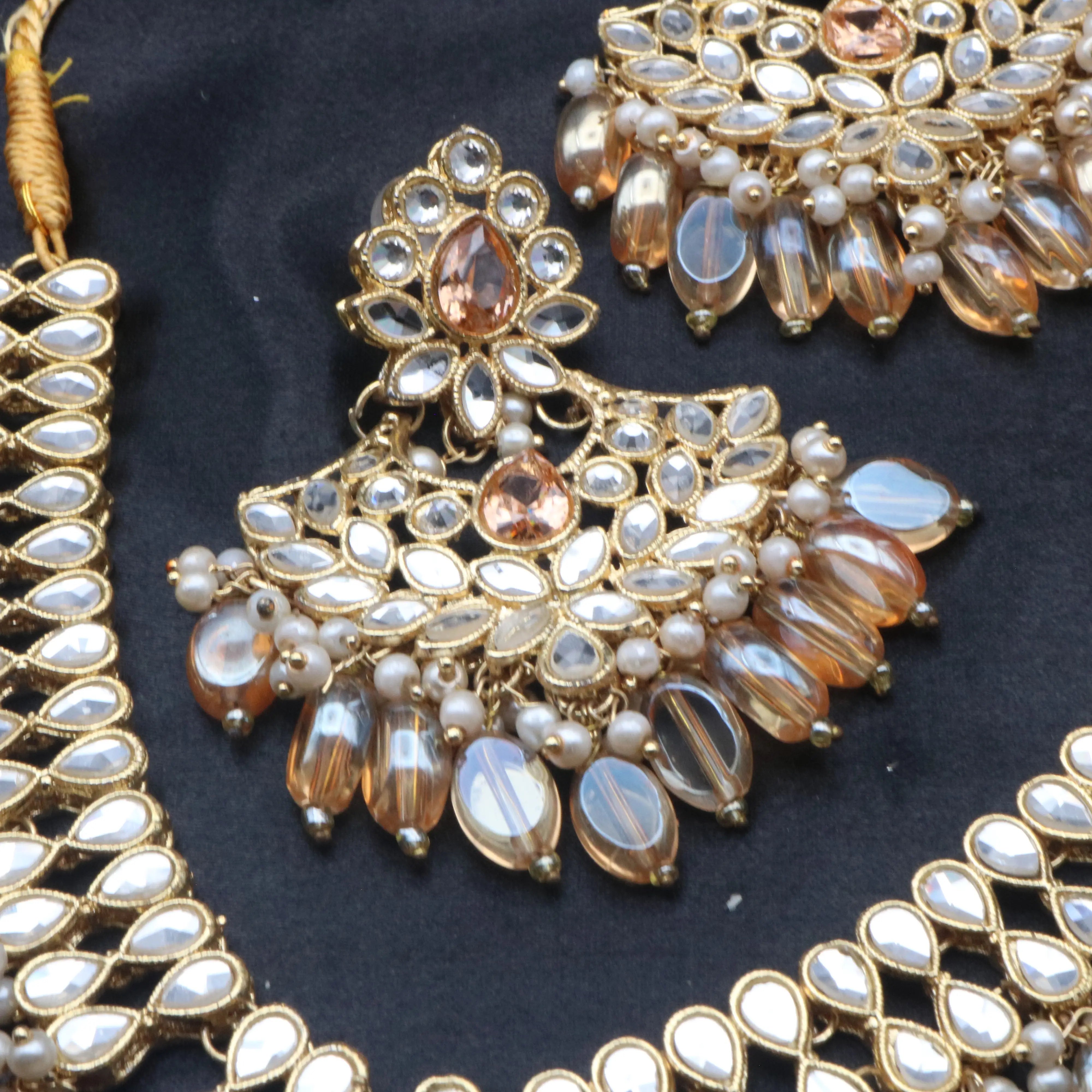 Detailed shot of Coral earrings with kundan work, glass beads, and pearl accents