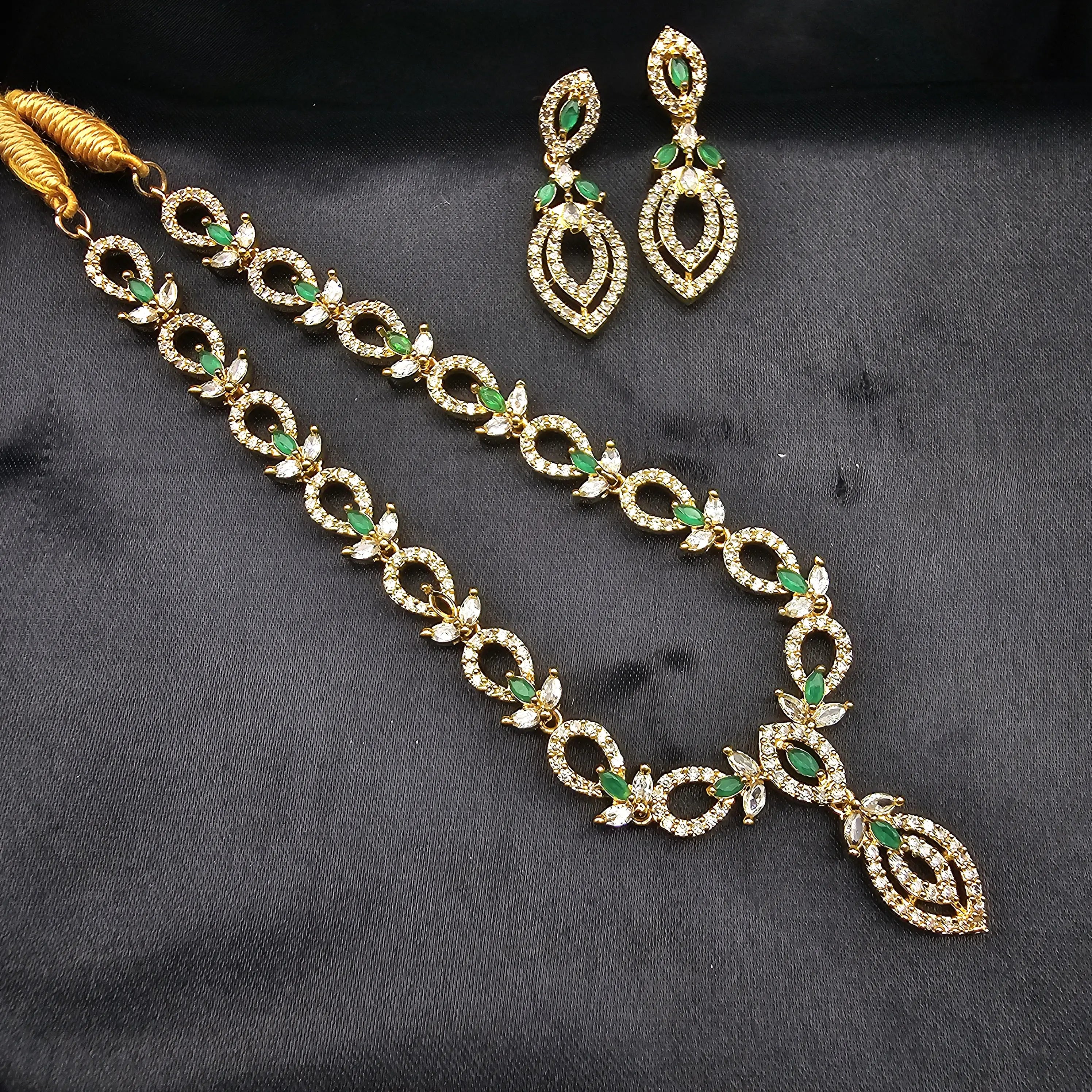 Cove set in emerald green on black satin background with gold-plated finish.