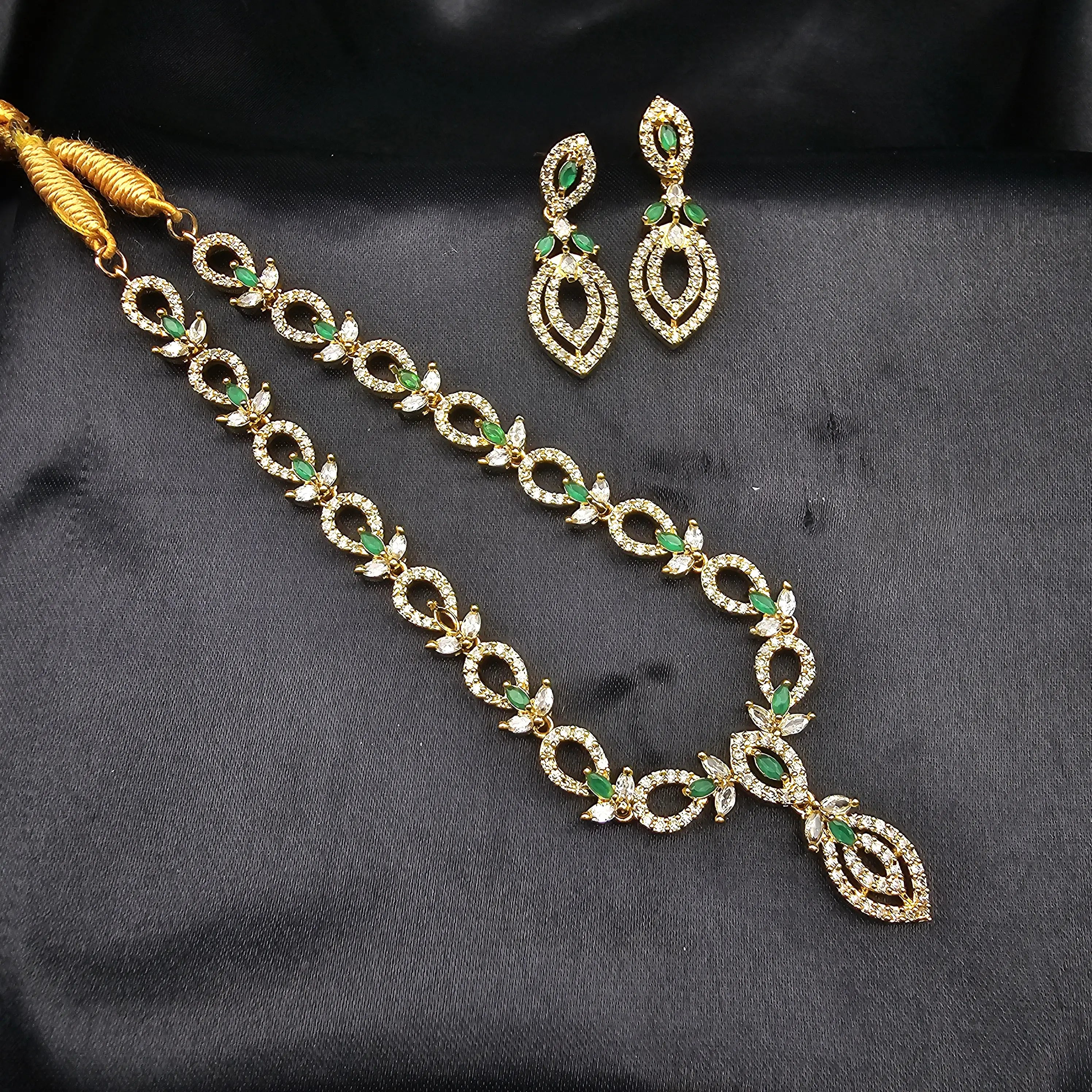 Top view of emerald green variant showing earrings and necklace with white accent CZs.