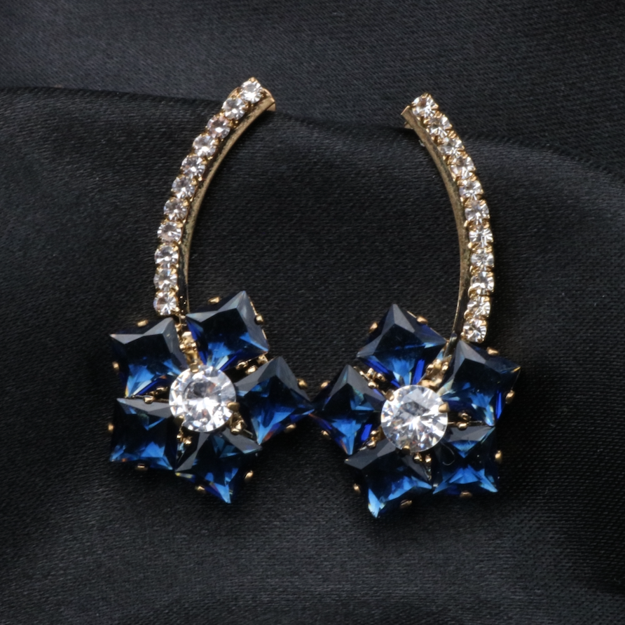 A pair of stainless steel and gold-plated earrings with blue and clear American diamonds.