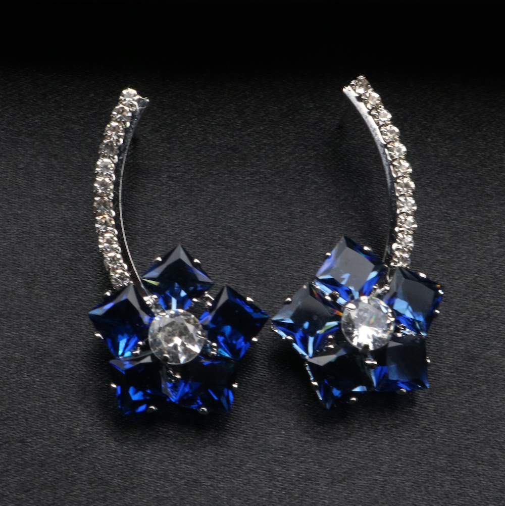A pair of stainless steel and gold-plated earrings with blue and clear American diamonds.