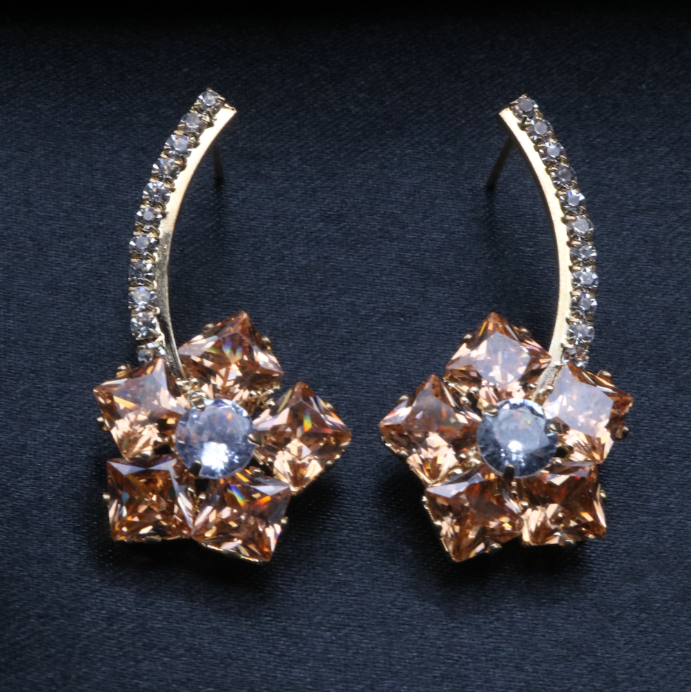 A pair of stainless steel and gold-plated earrings with champagne and clear American diamonds.
