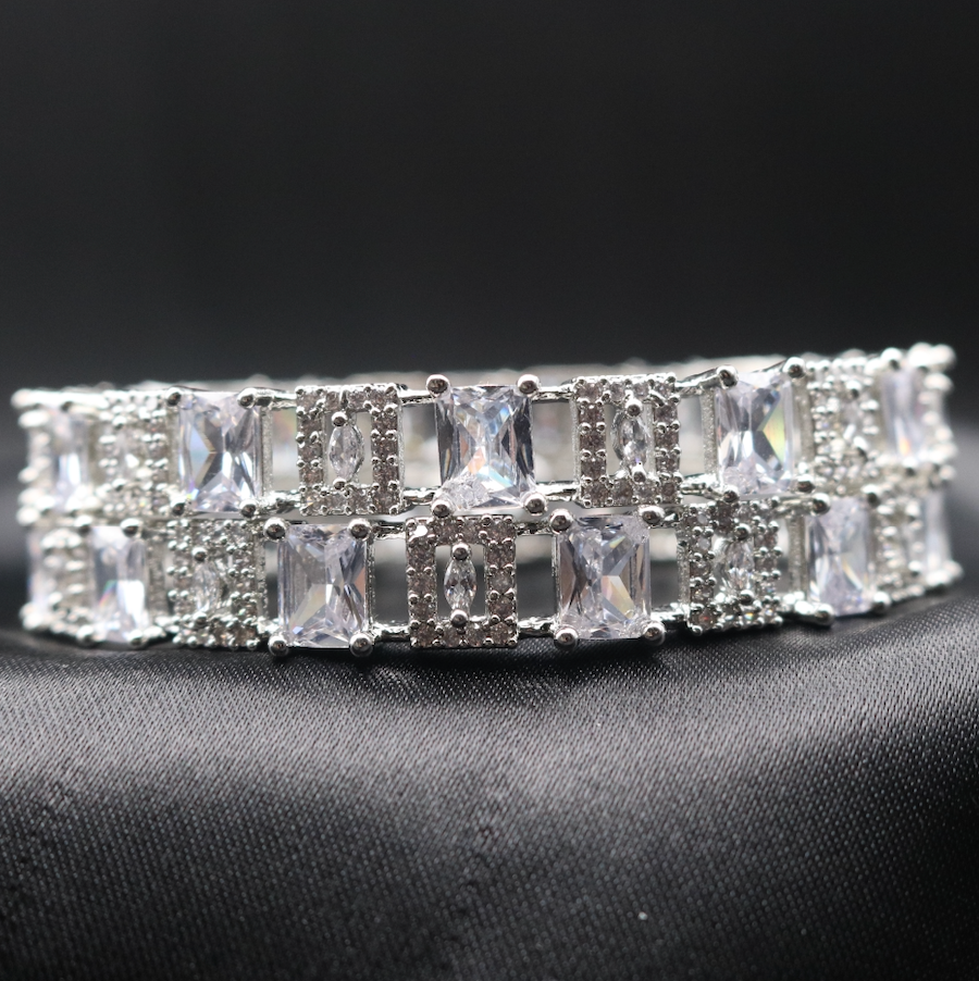 Silver bangles adorned with clear gemstones, showcasing its sparkle and design.