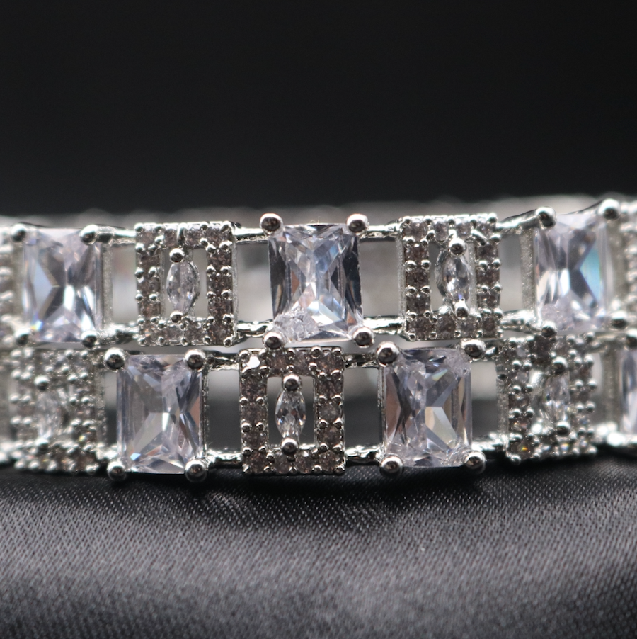 silver bangle bracelet adorned with clear stones, showcasing its sparkle and design.
