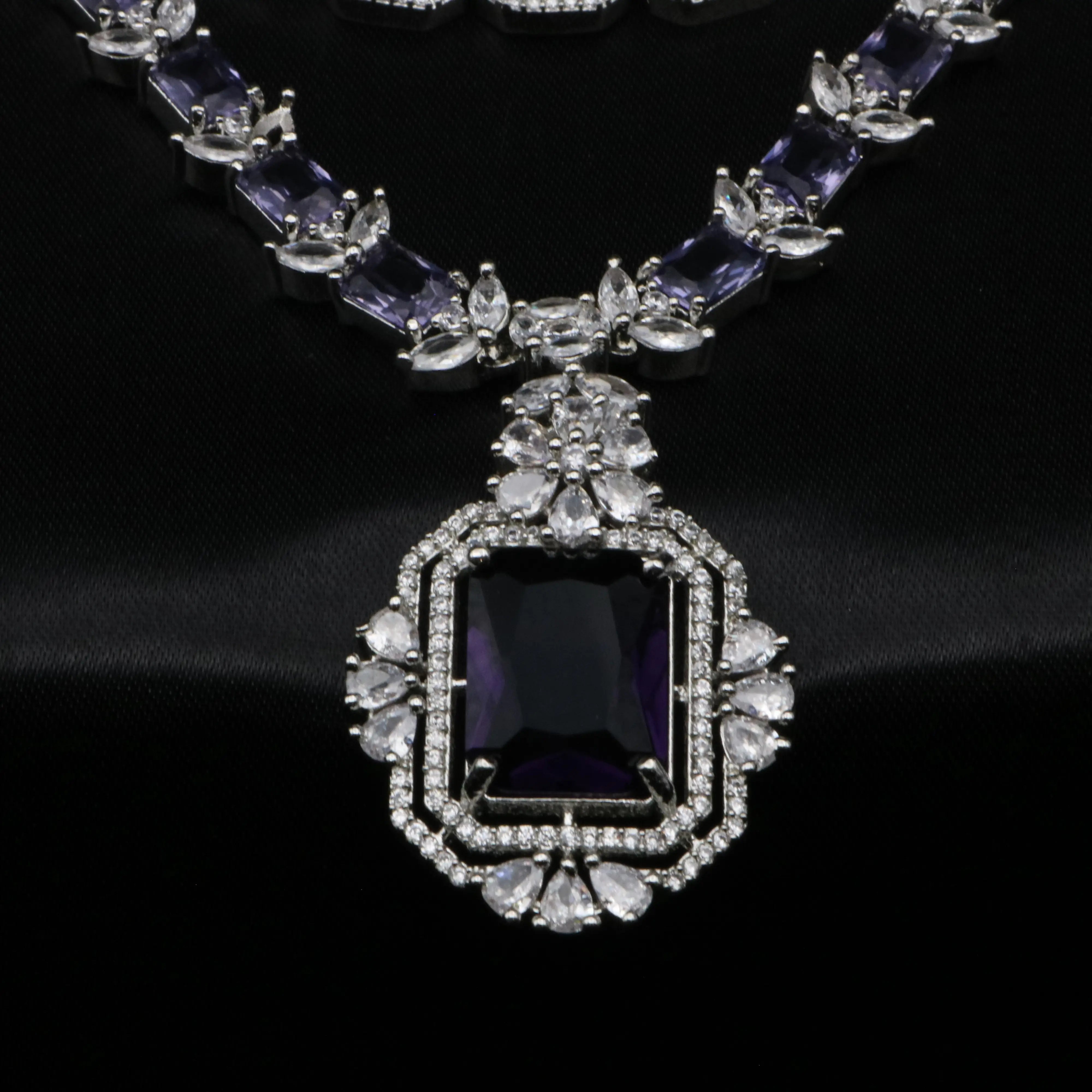 Detailed view of rectangular pendant with CZ border and floral accents in Elegant set