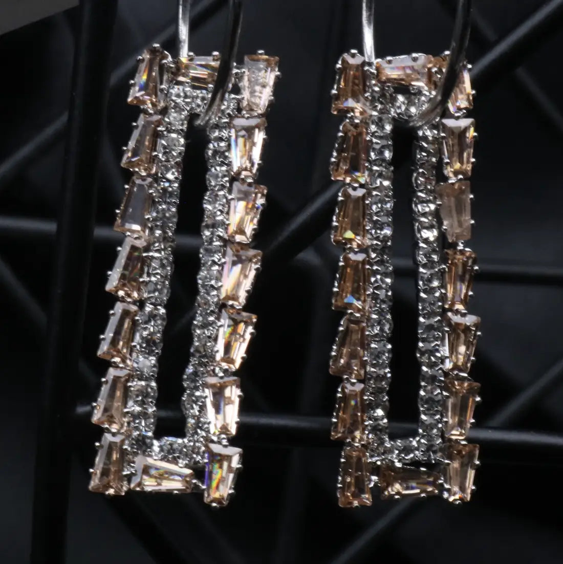 Pair of champagne earrings with silver base on a black background