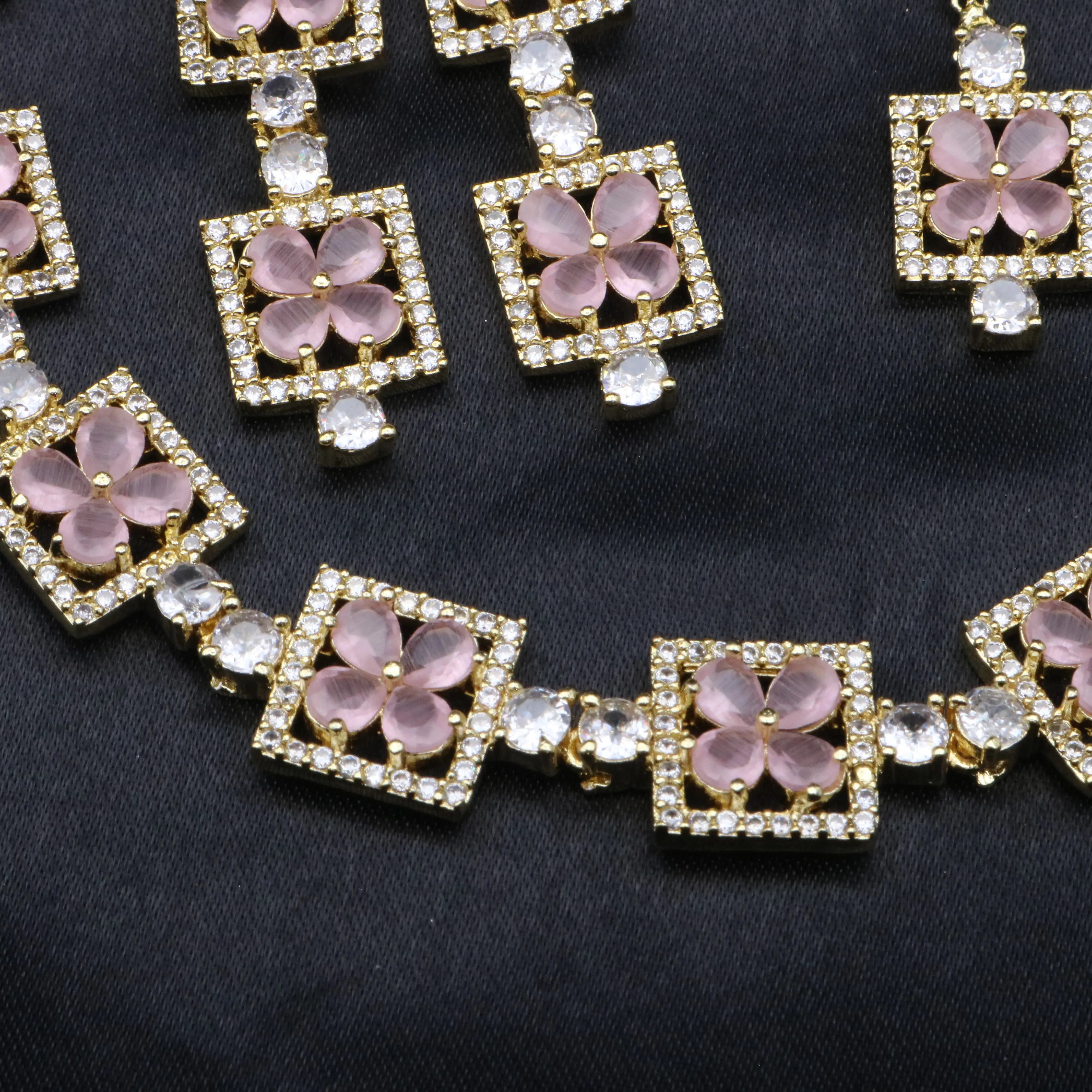 Detailed view of Fleur rose pink CZ necklace showcasing petal cut stones and pavé borders.
