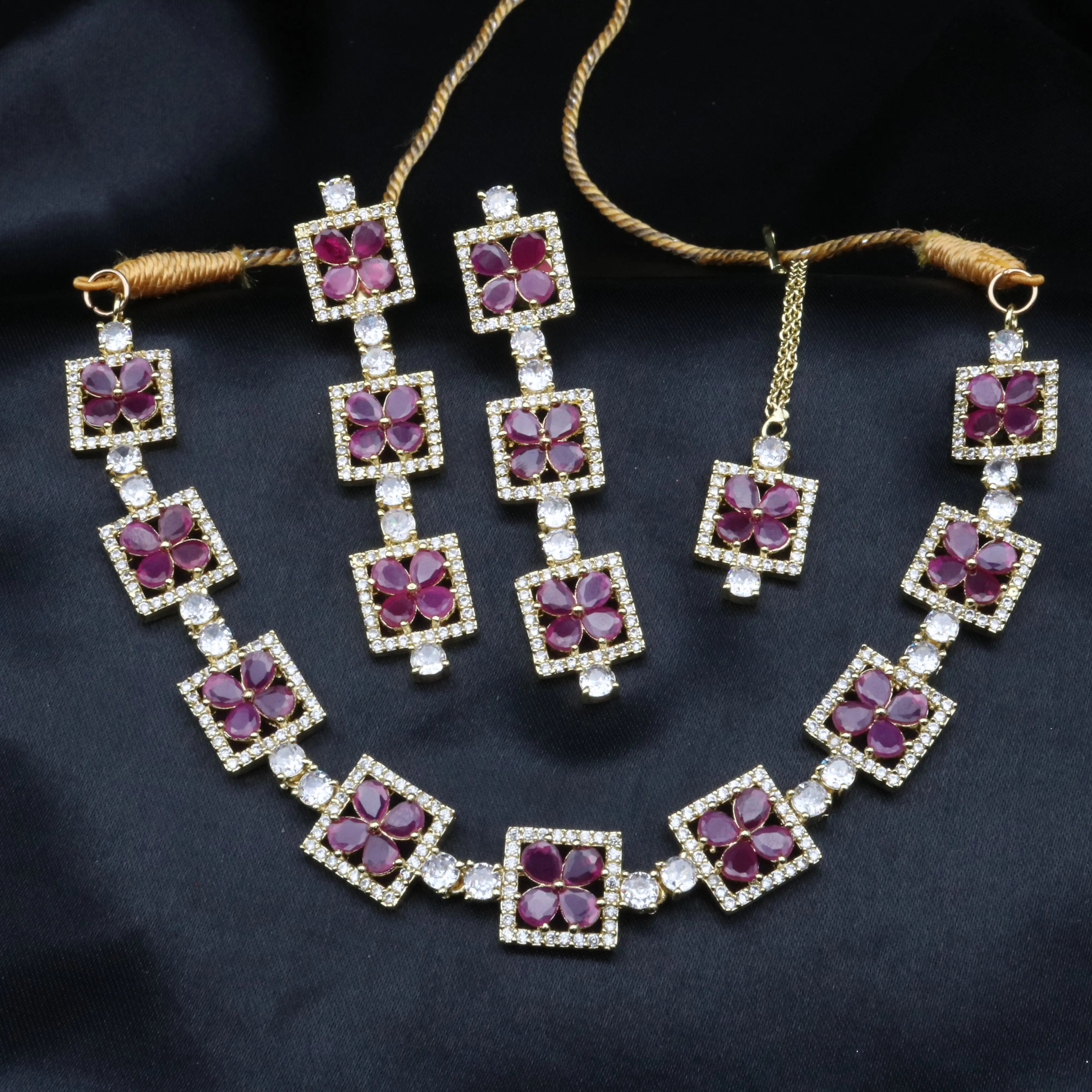 Fleur full ruby red necklace set with earrings displayed flat against black fabric.