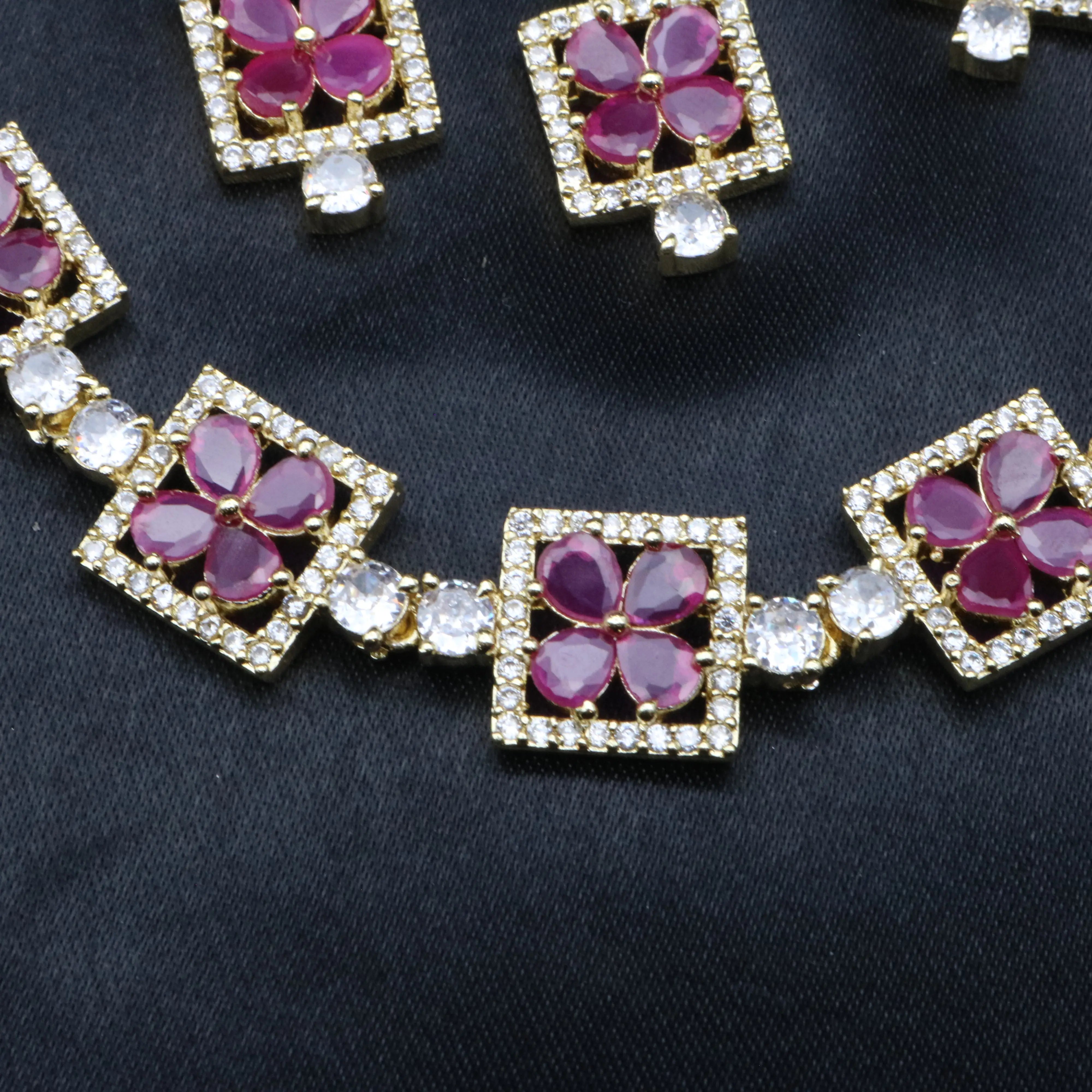Zoomed-in detail of ruby red petal stones and square CZ frames from Fleur necklace.