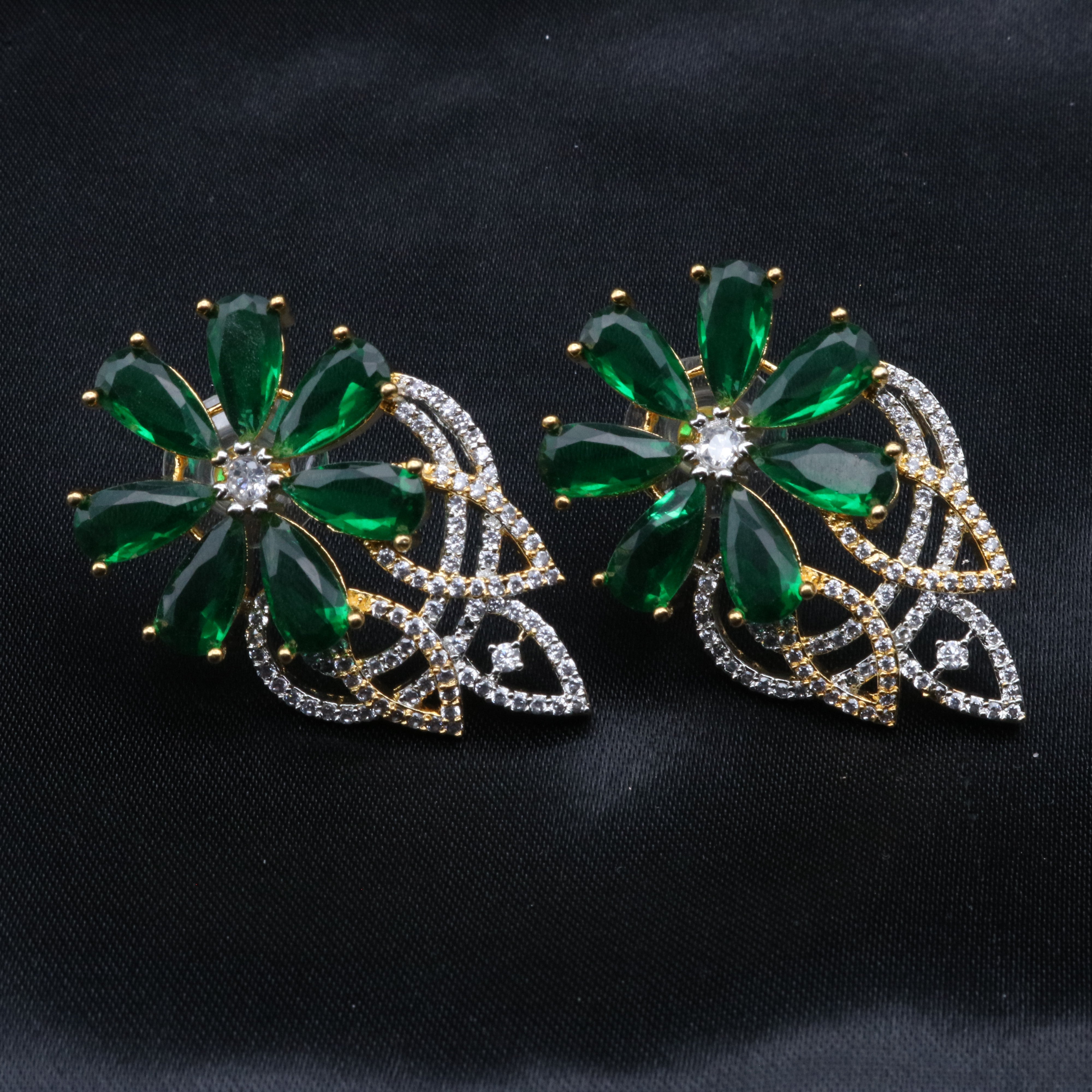 A pair of earrings with a floral pattern, featuring green colors, adorned with gold and clear embellishments.