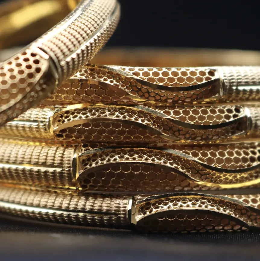 Close-up of Gold bangles showing modern honeycomb and ribbed texture