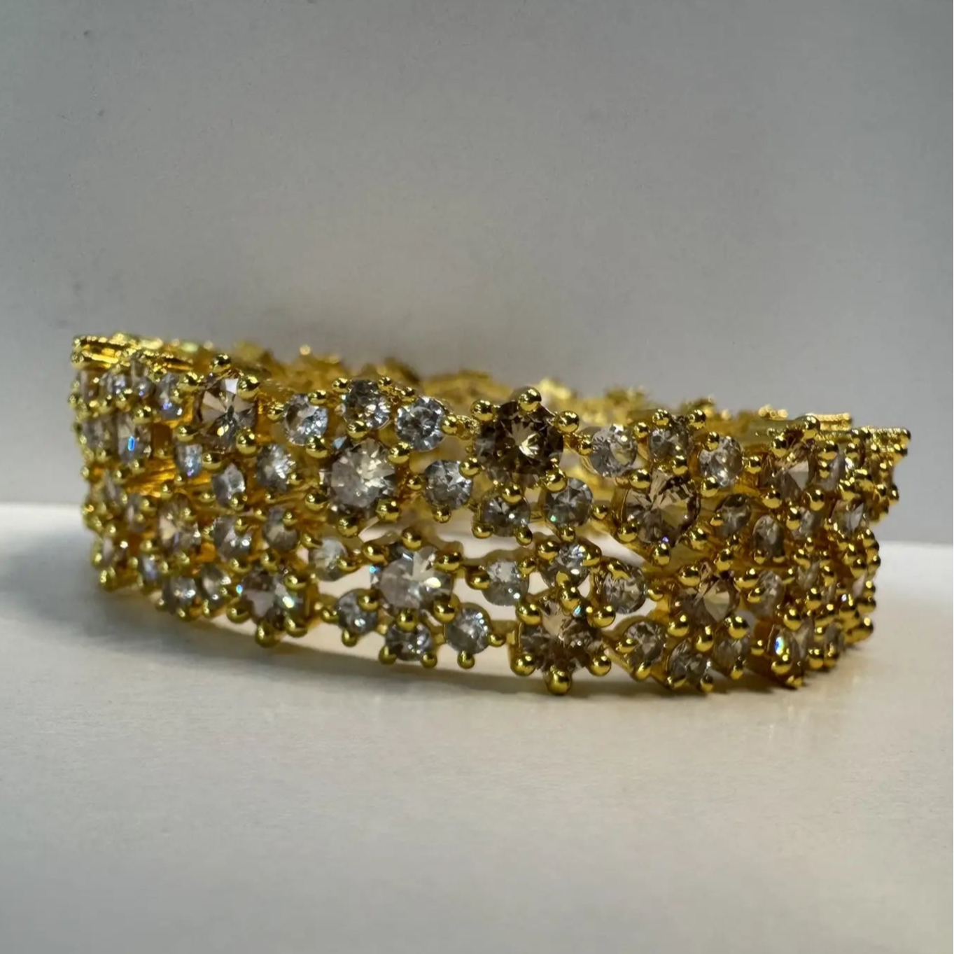 Gold-plated and American diamond bangle set on a white background 