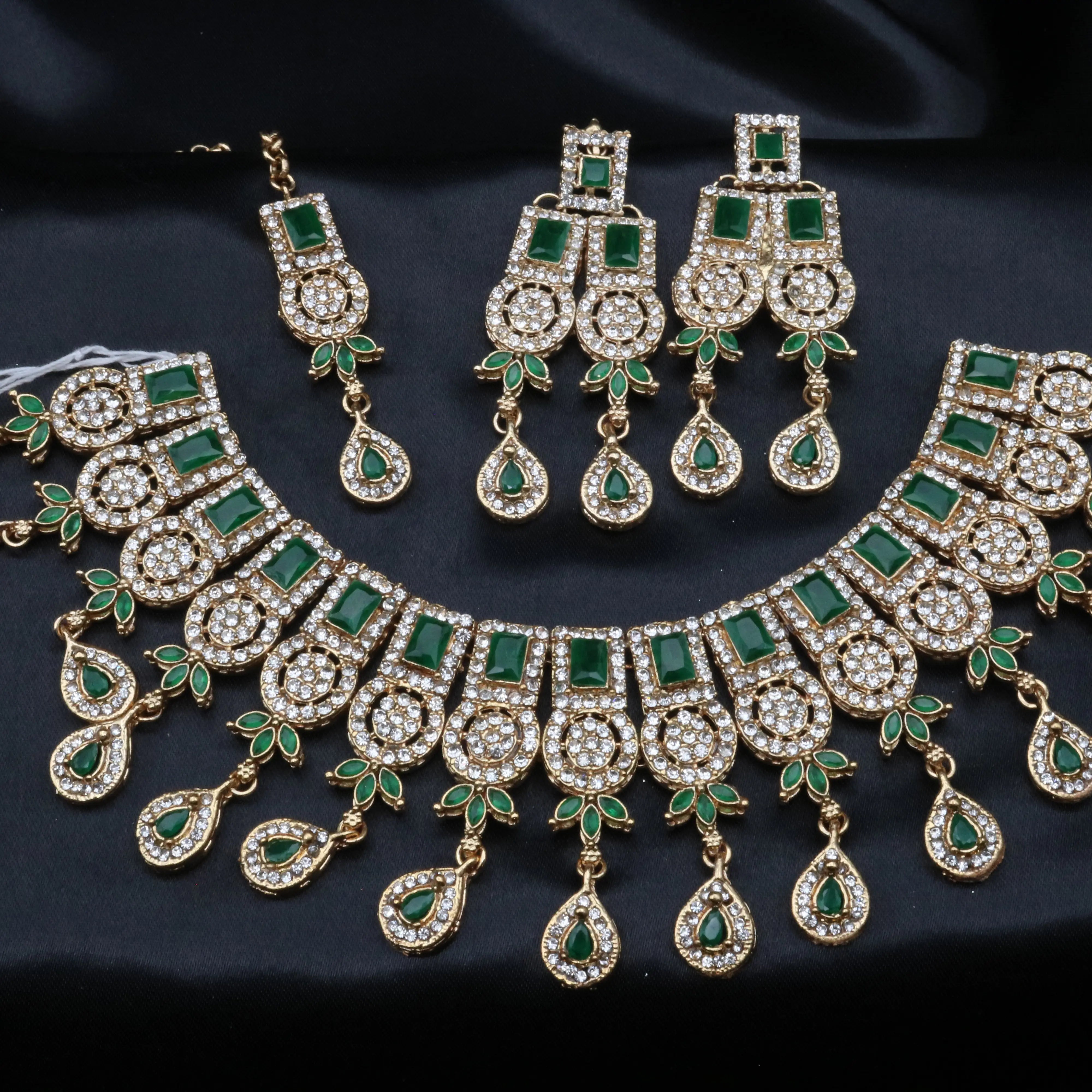 Emerald green Ishq variant with gold base, paired with matching earrings and tikka.