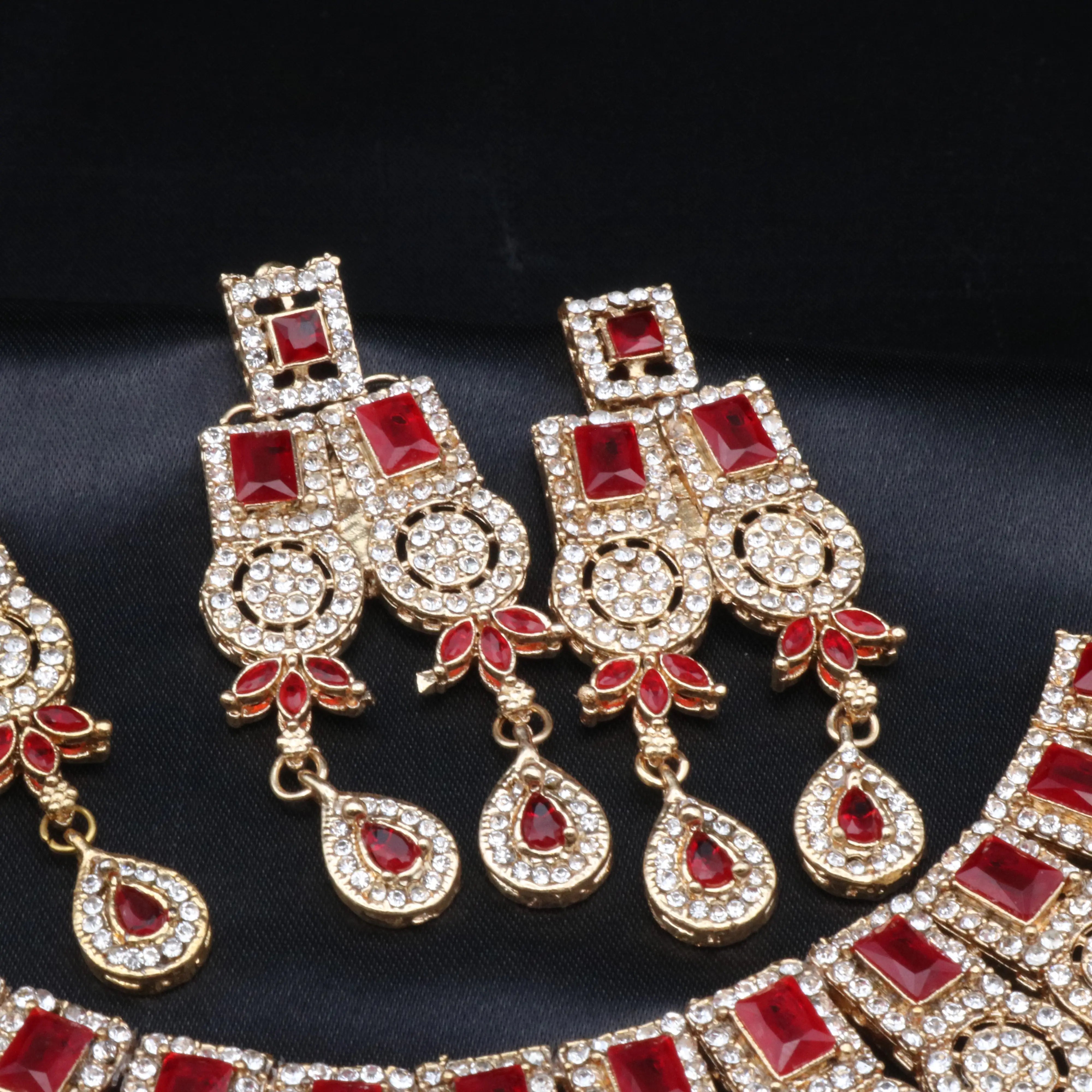 Close-up of red Ishq set showcasing double-row earrings and embellished red CZ drops.