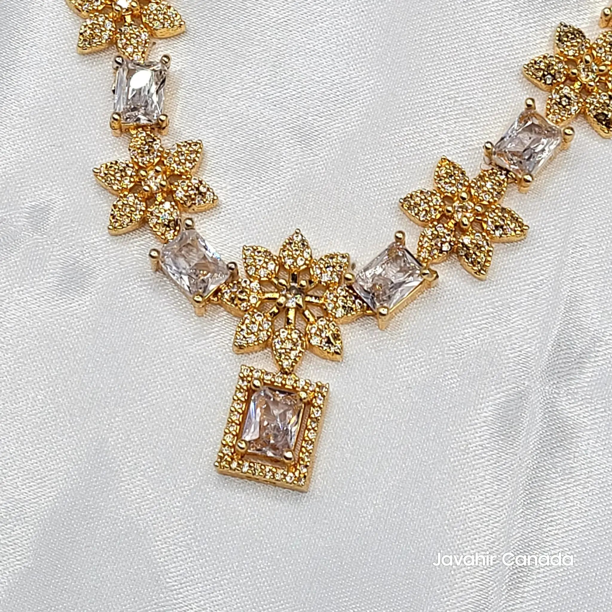 Close-up of JV154 pendant showing detailed gold floral design with CZ centerpiece.