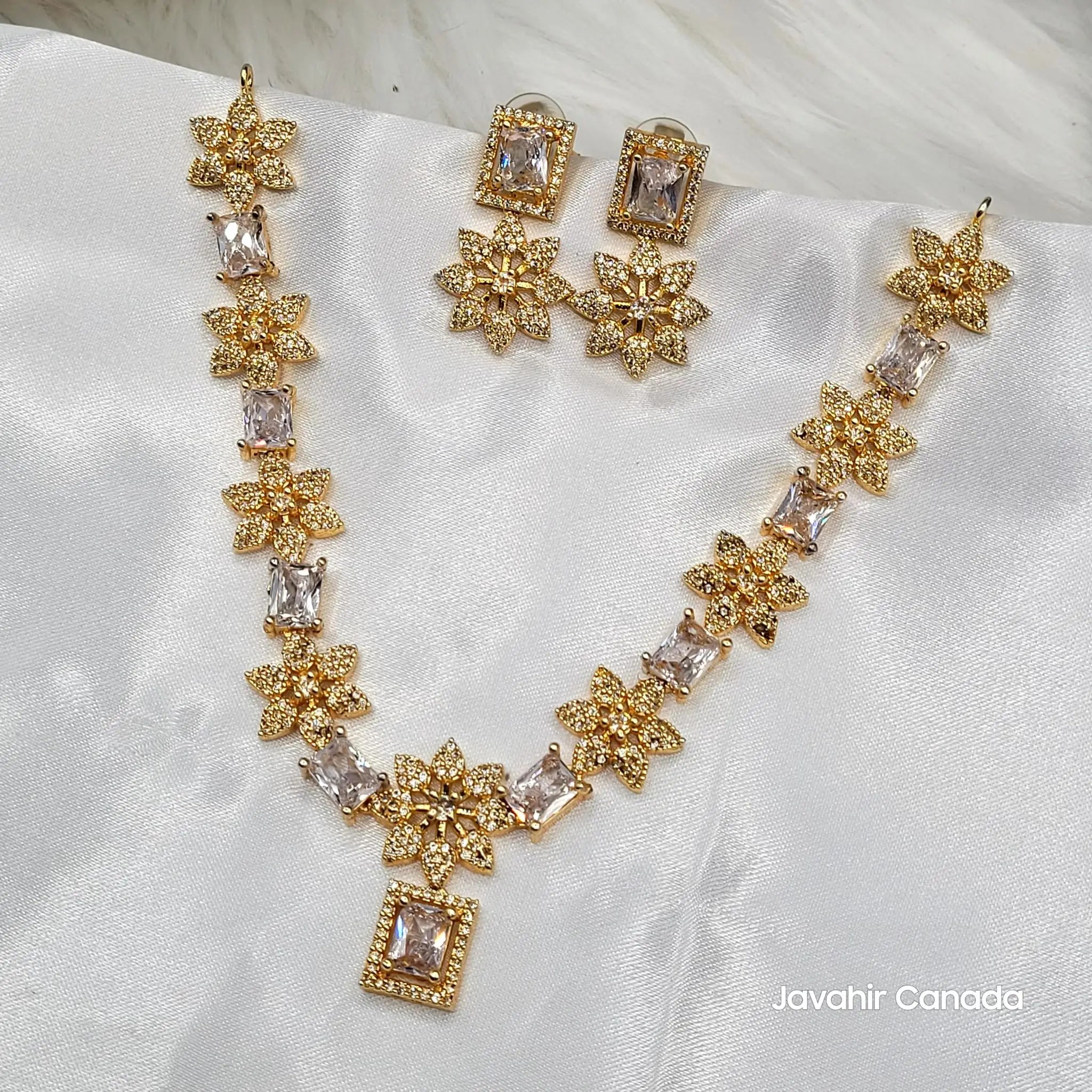 JV154 floral necklace set with square-cut CZ stones on white satin background.